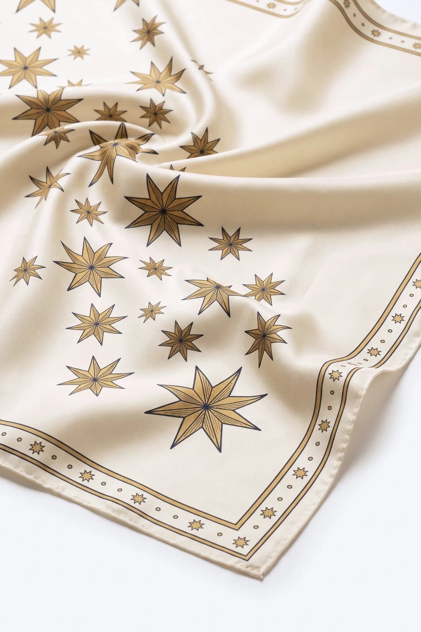 Close-up on the folds of the Pluie d'étoiles silk scarf, silk twill and hand-rolled edge