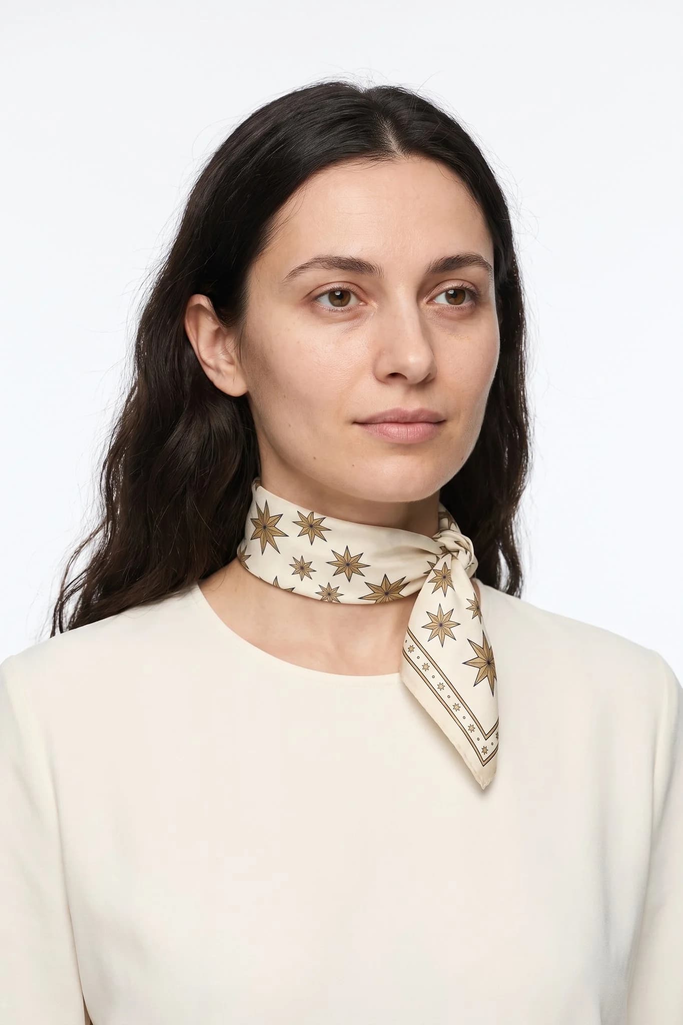 Small silk scarf 50 Pluie d'étoiles worn tied around the neck as a small scarf by a woman, studio view