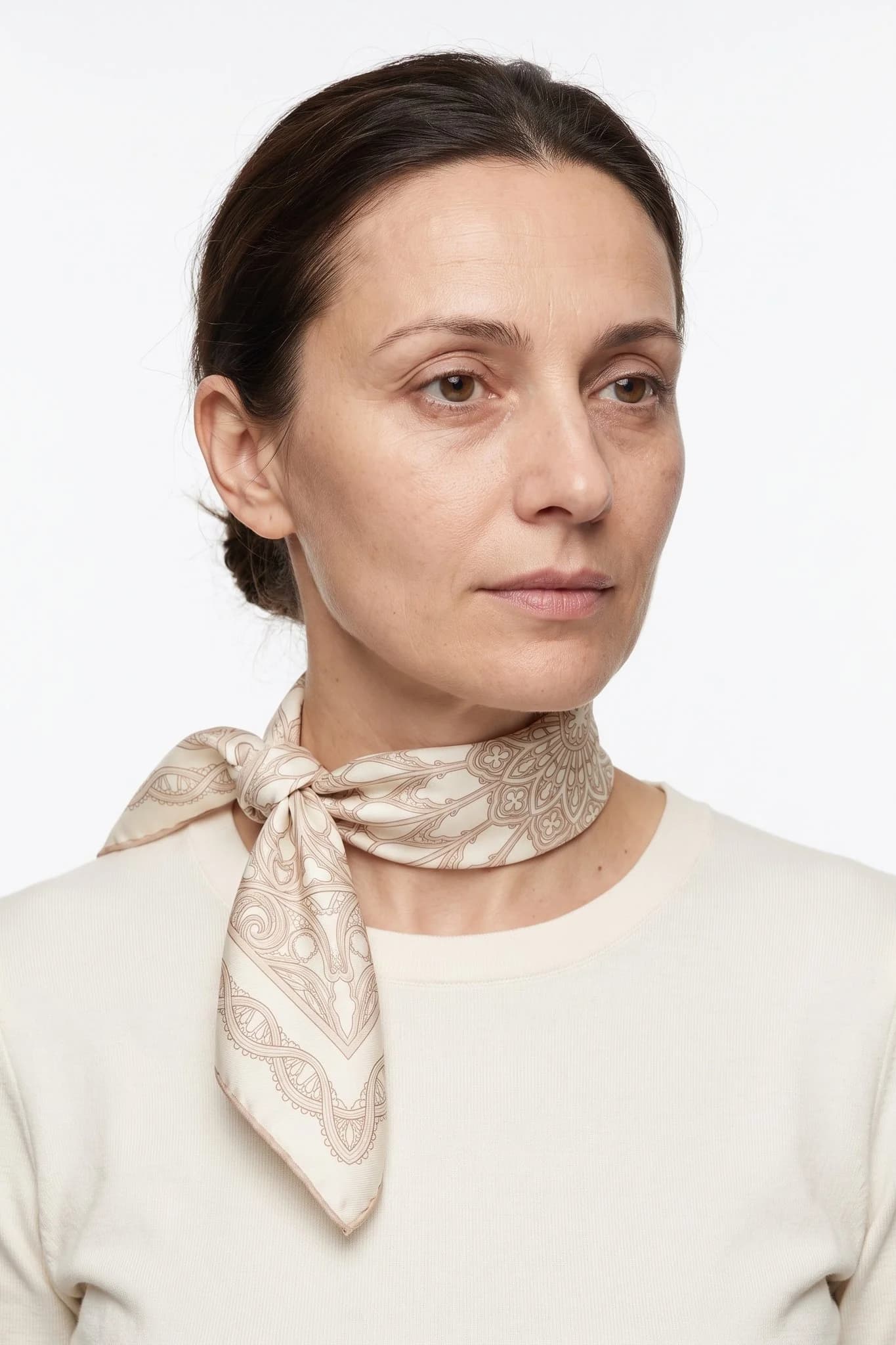 Small silk square 50 Rosace de fil worn tied around the neck as a small scarf by a woman, studio view