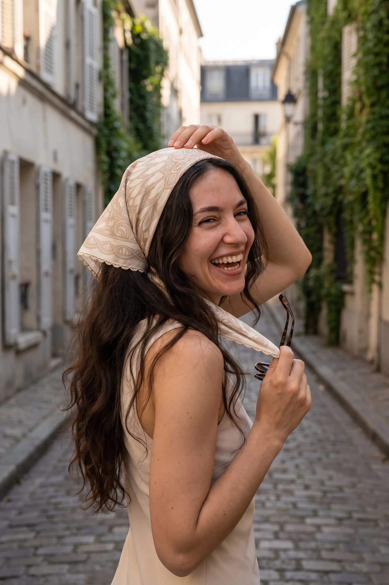 Woman wearing the silk square Rosace de fil as a bandana in her hair on a Paris street