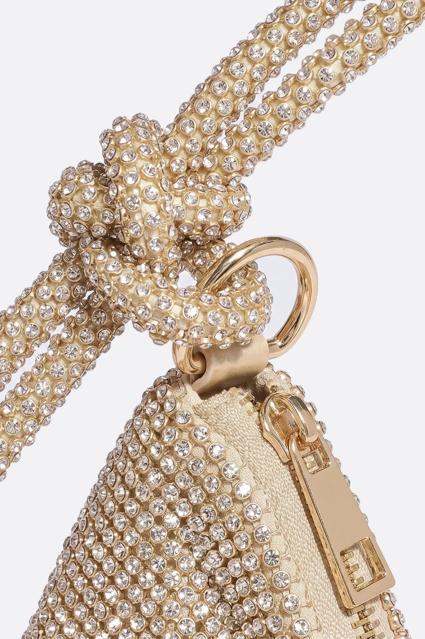 Primo piano del manico annodato e della chiusura dorata della pochette in strass
