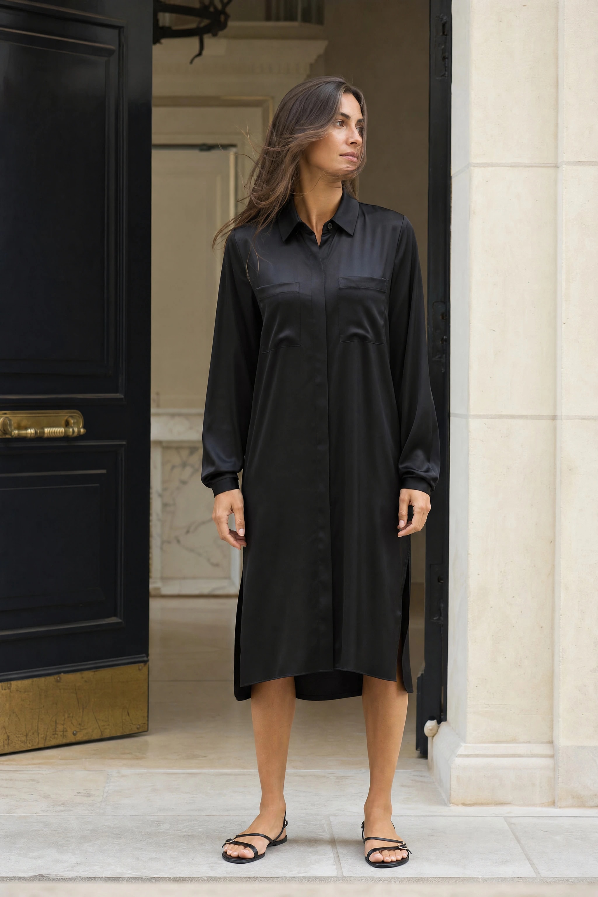 Robe chemise longue en satin noir portée sur une place italienne en fin d'après-midi