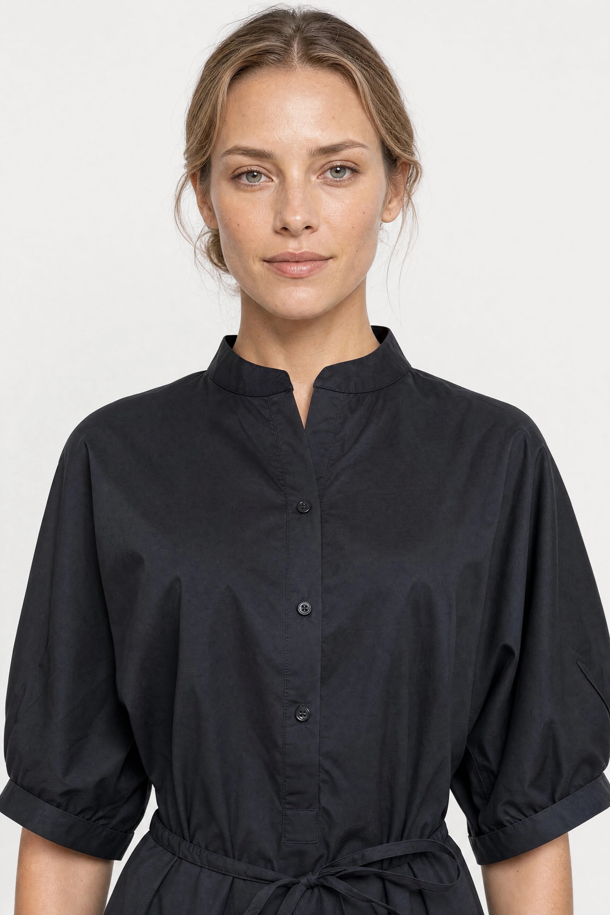 Bust of the black cotton shirt dress worn, officer collar open at the neckline and first buttons