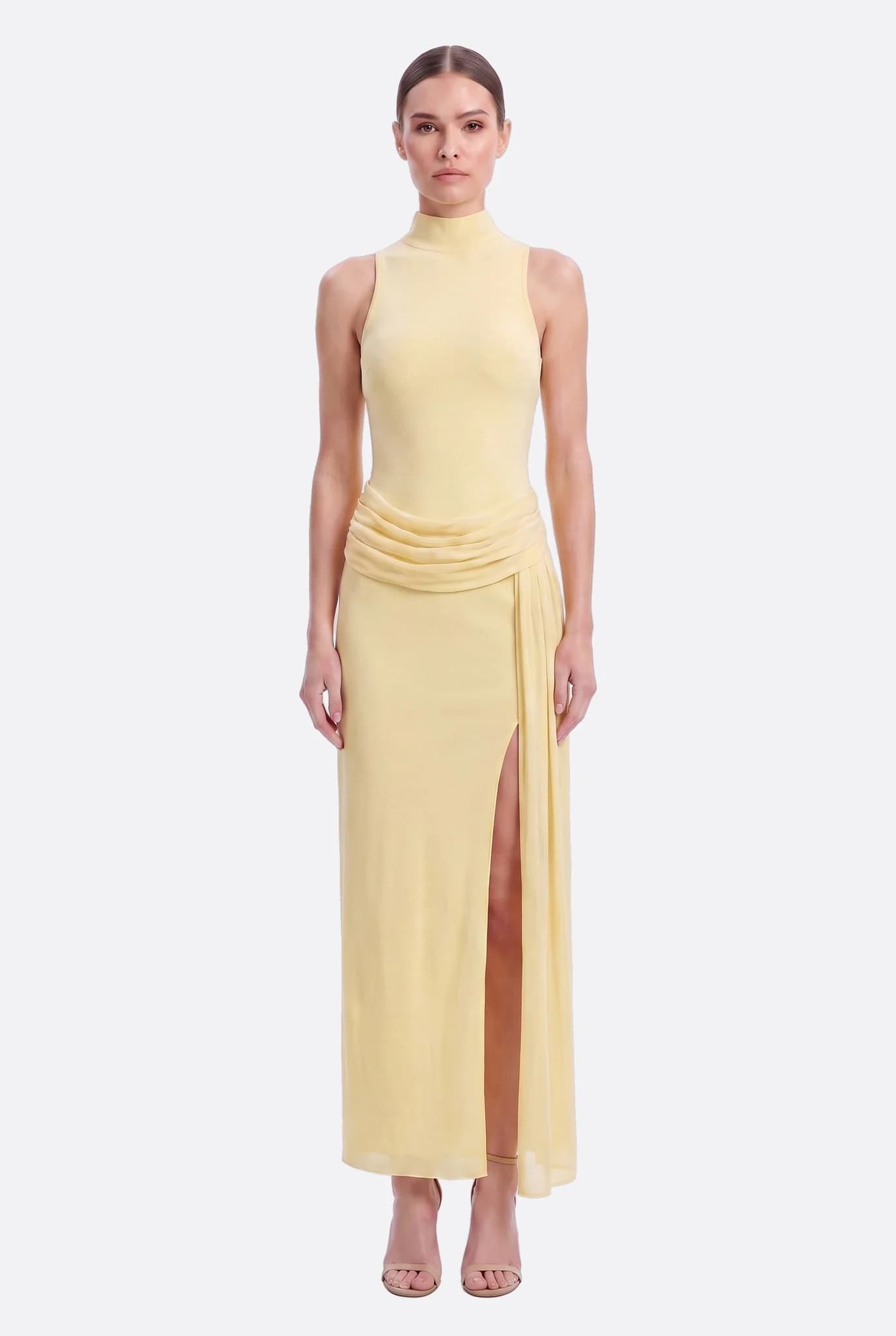 Vestido largo amarillo pastel con cuello alto visto de frente, drapeado anudado a la cintura y abertura frontal