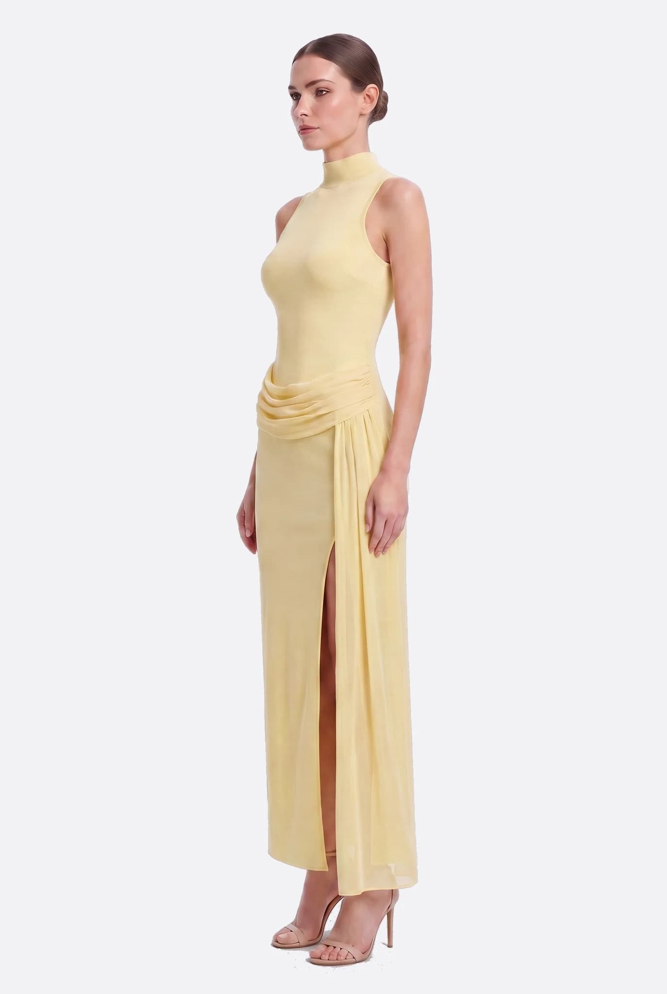 Modelo de perfil vistiendo el vestido largo drapeado amarillo pastel, silueta de vaina y abertura visible