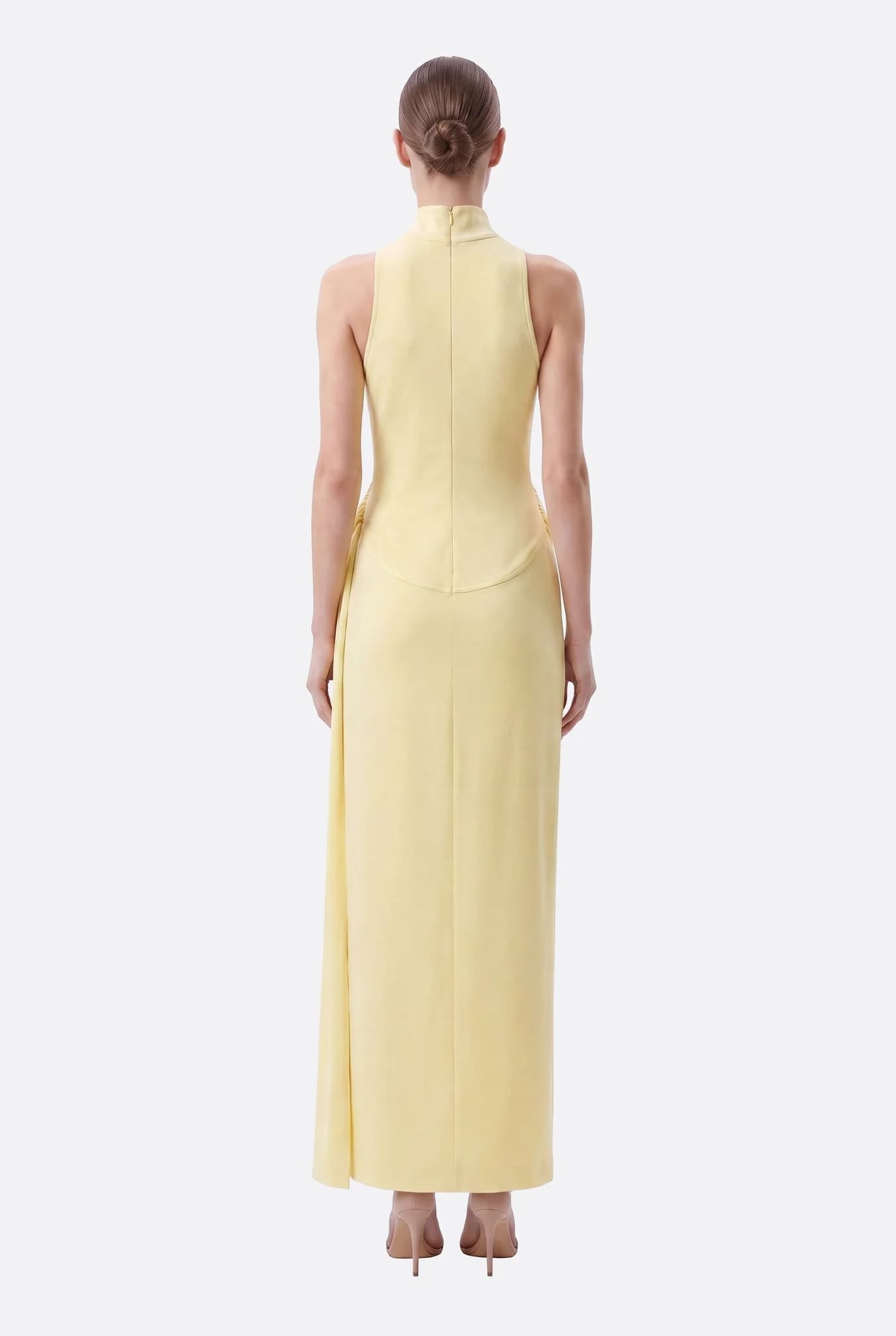 Vestido largo amarillo pastel visto desde atrás, cuello alto y sisas escotadas