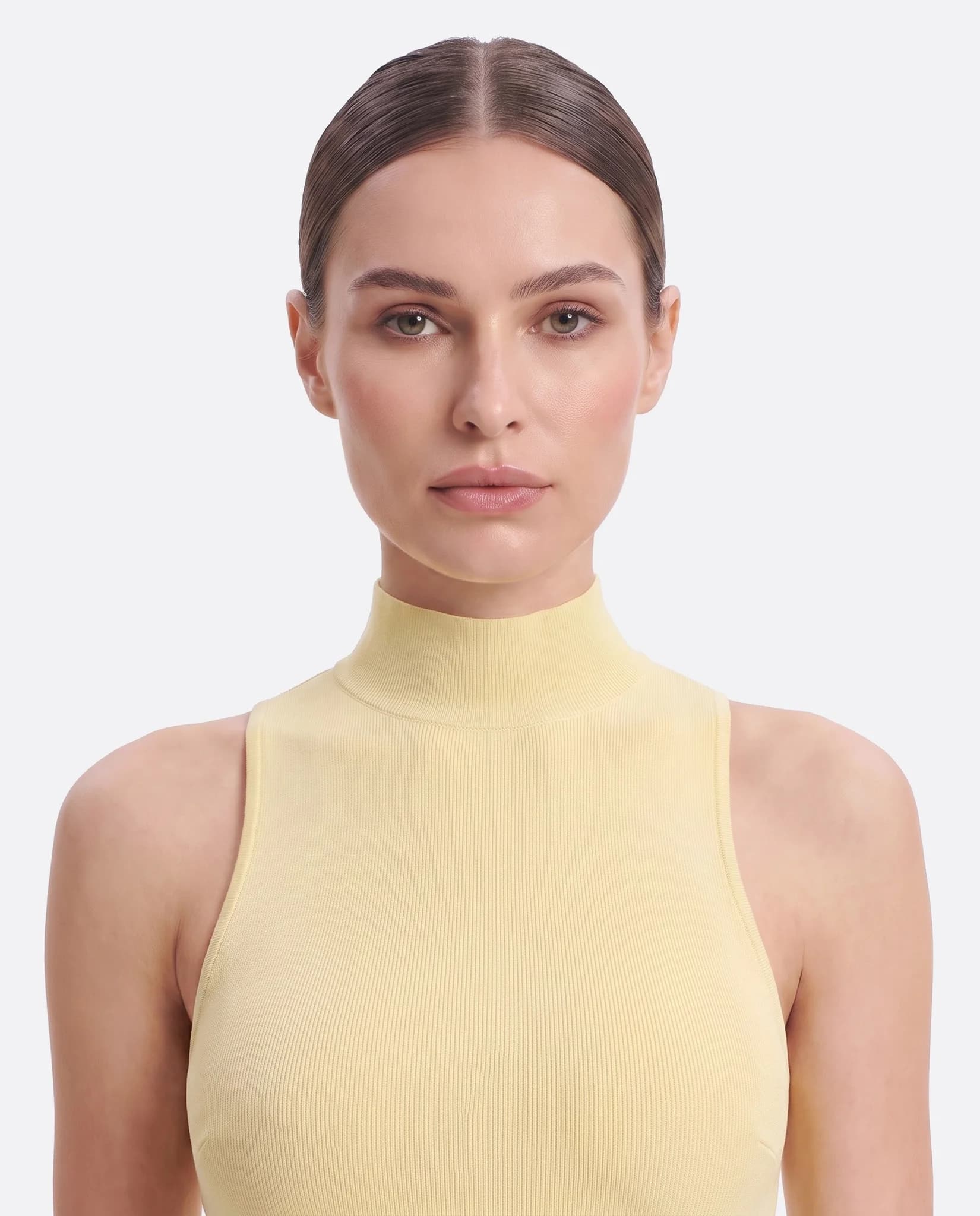 Primer plano del cuello alto y las sisas escotadas del vestido largo amarillo pastel Misciano