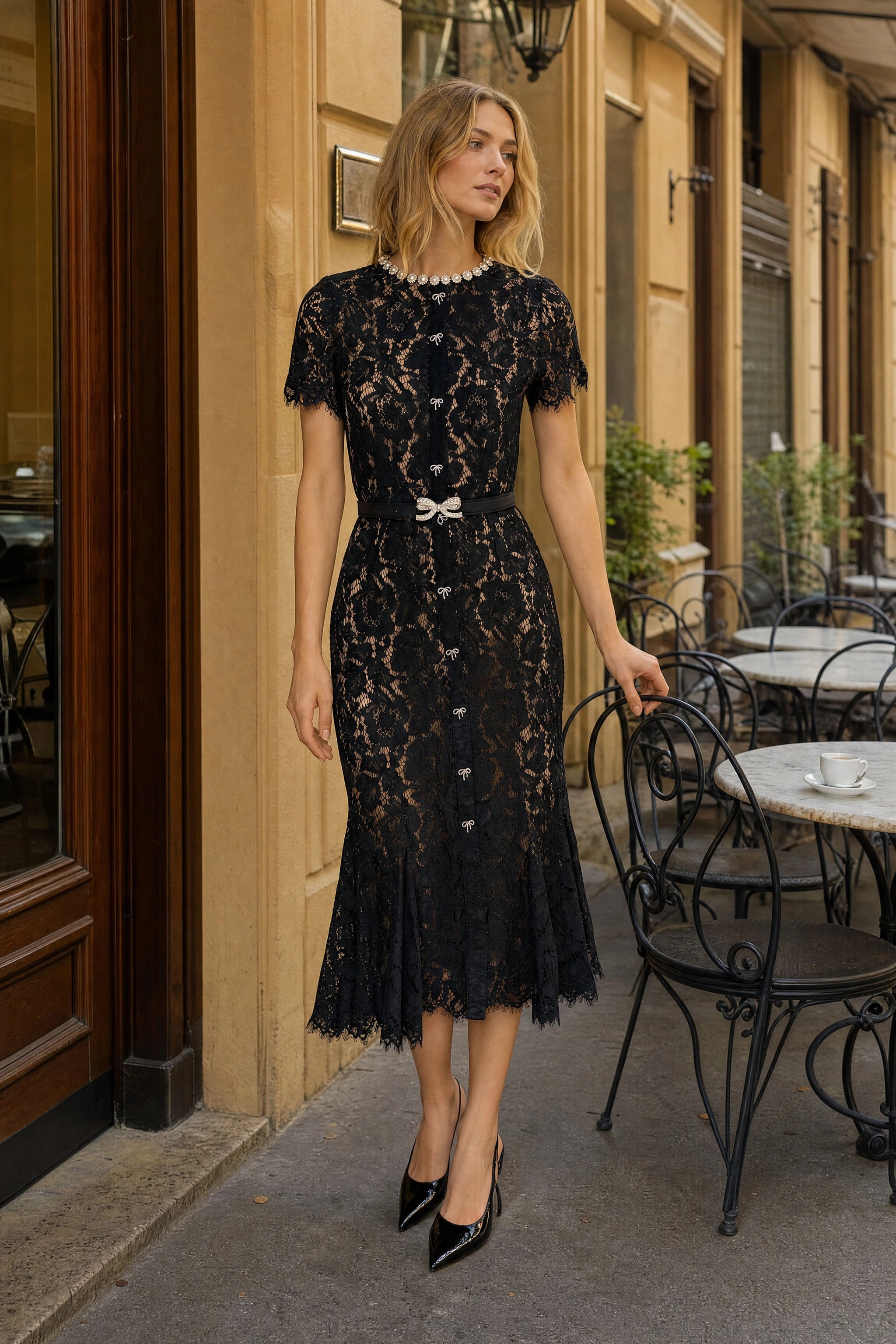 Vestito midi in dentelle cordonnée nera con colletto perlato indossato in una terrazza di un caffè milanese in autunno