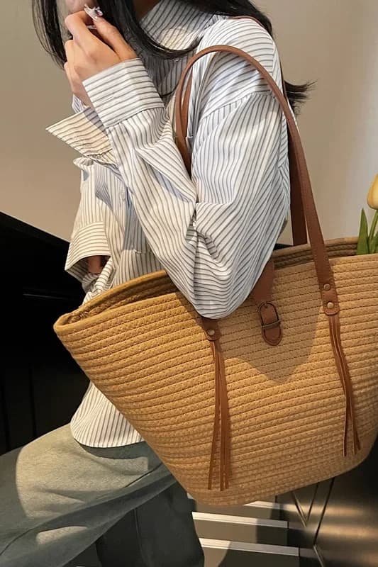 Sac cabas tressé effet paille marron porté à l’épaule