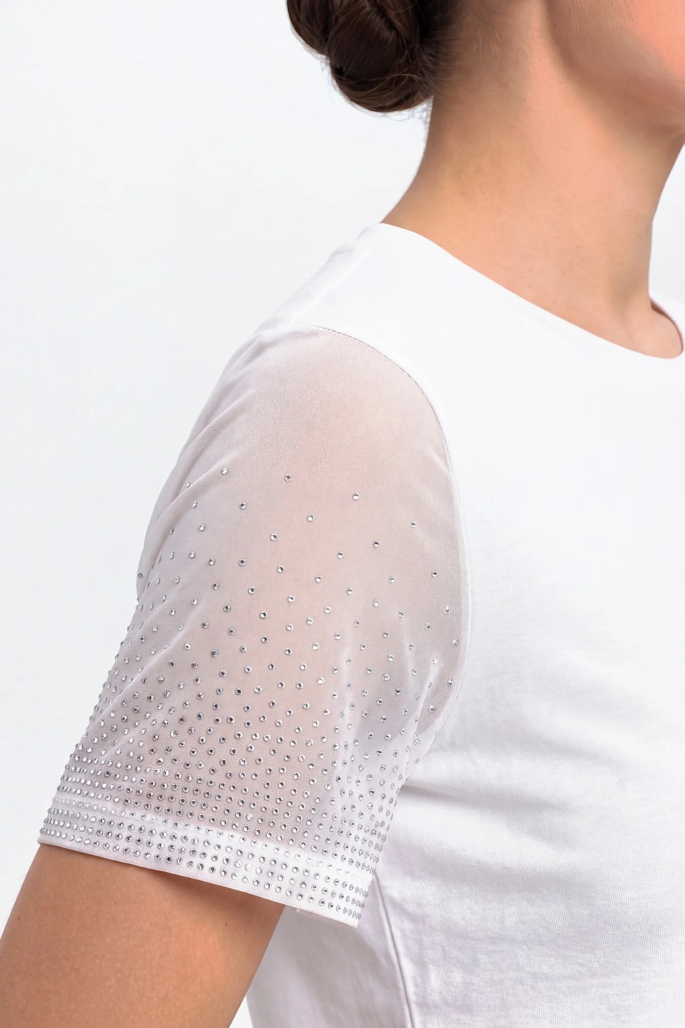 Détail de la manche en voile blanc transparent semée de cristaux de plus en plus denses