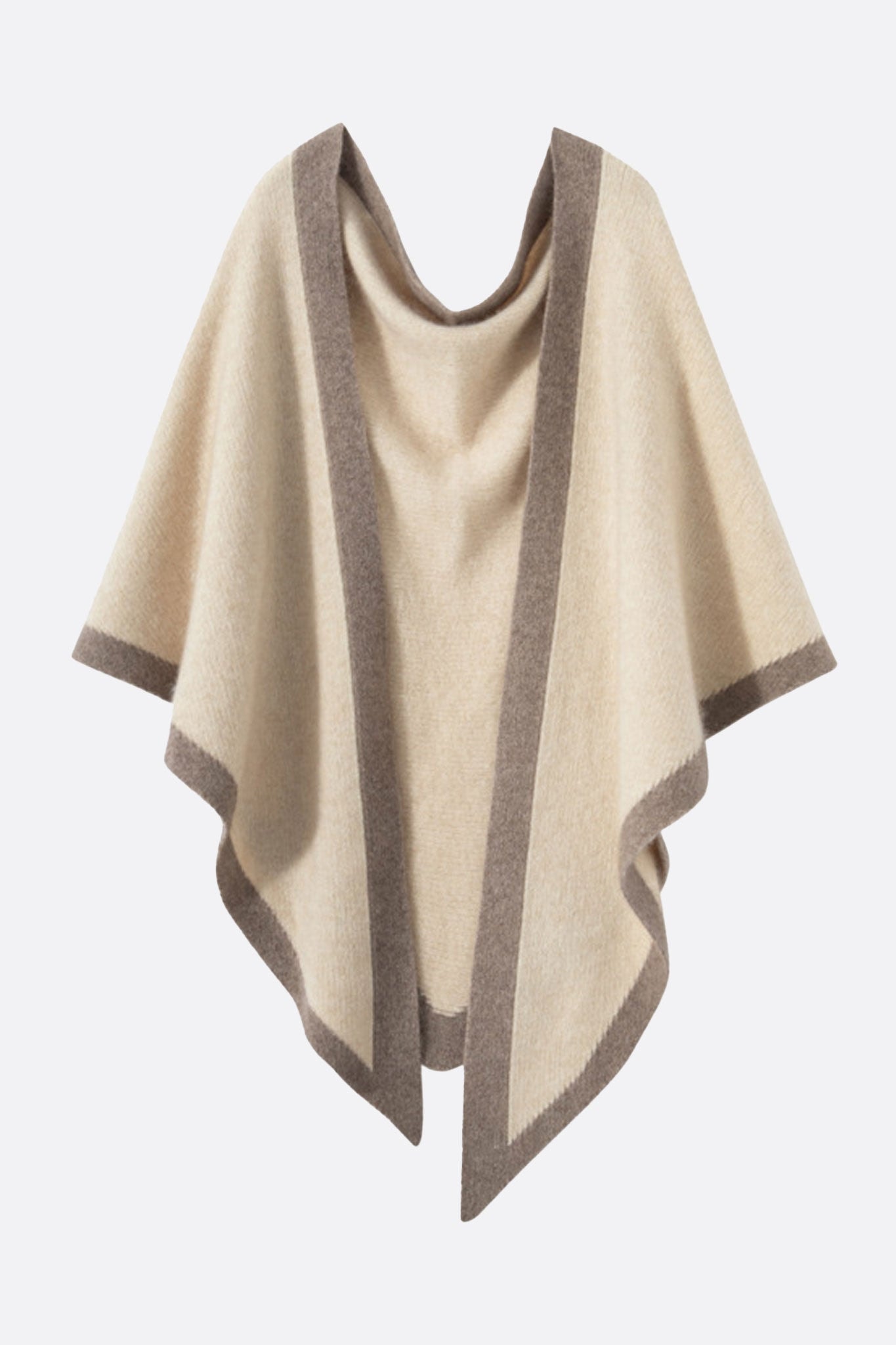 Primer plano del poncho de cachemir beige con bandas topo, una pieza chic para cubrirse en las noches de verano.