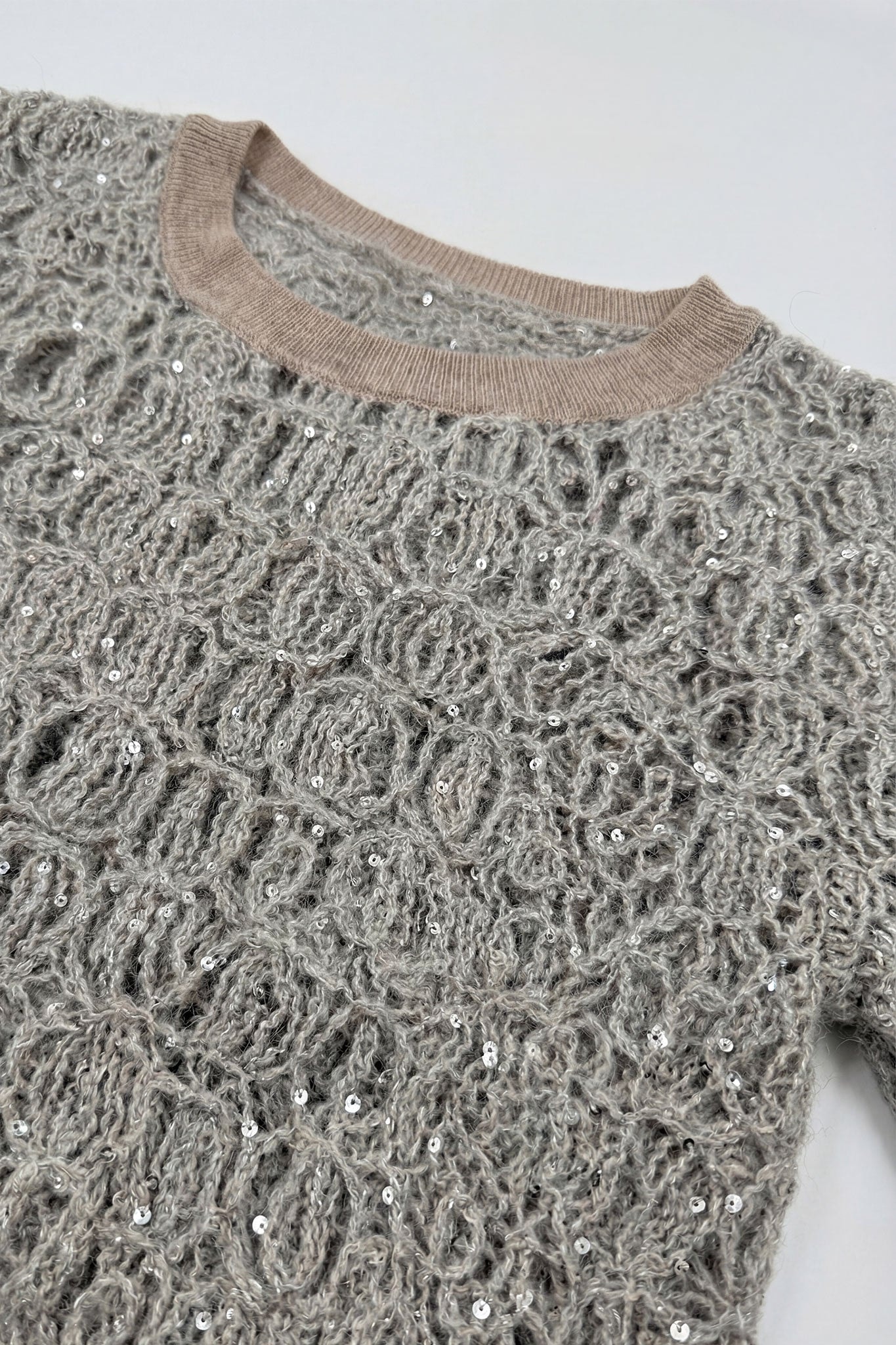 Feine Details des durchbrochenen perlgrauen Pullovers aus Mohair- und Lurexstrick, ideal, um Ihrem Stil eine raffinierte Note zu verleihen.