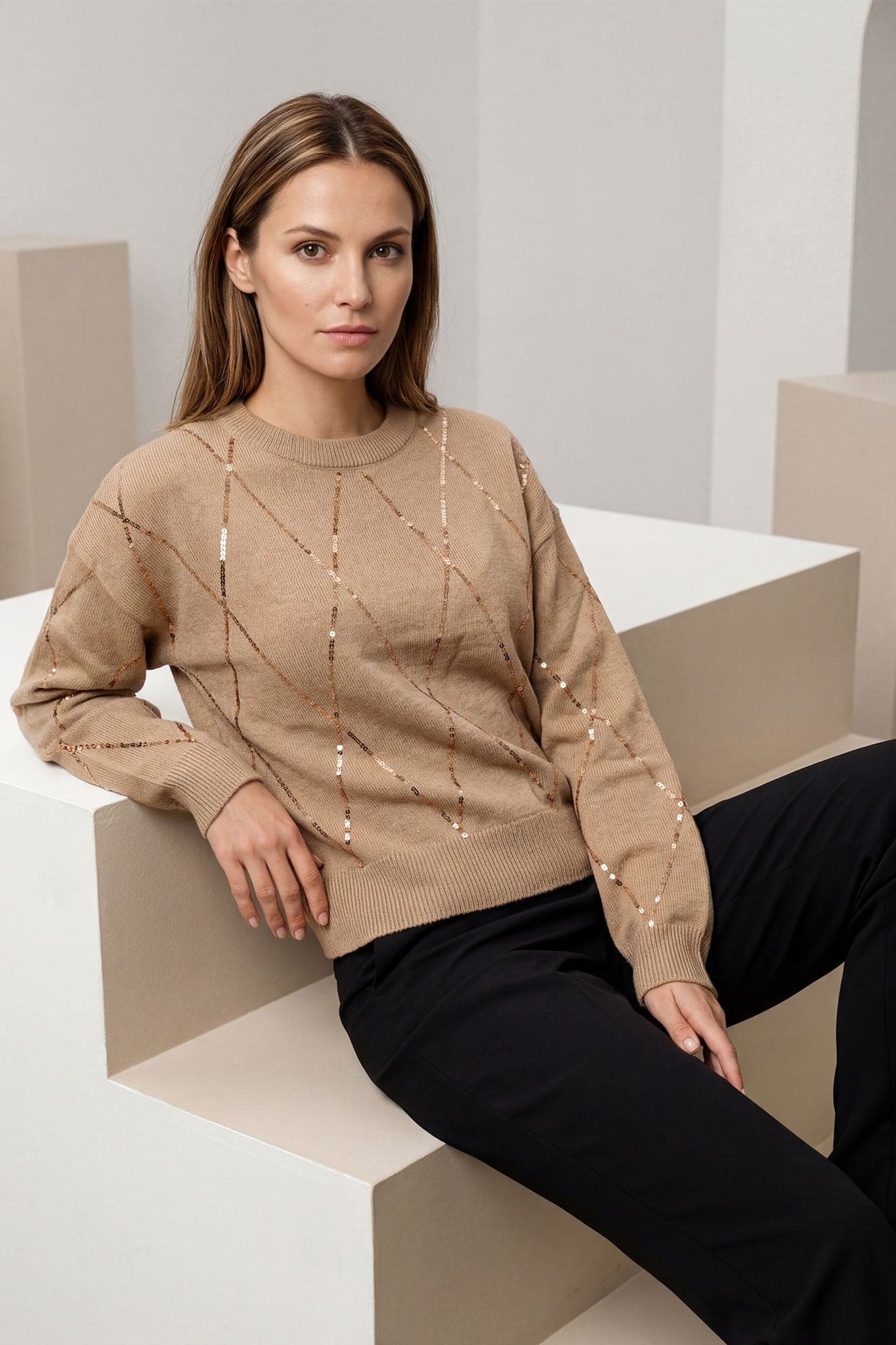 Details des beigen Pullovers aus Wollmischung mit funkelnden Glanzlichtern, eine elegante Wahl, um Ihre Abendoutfits zu verschönern.