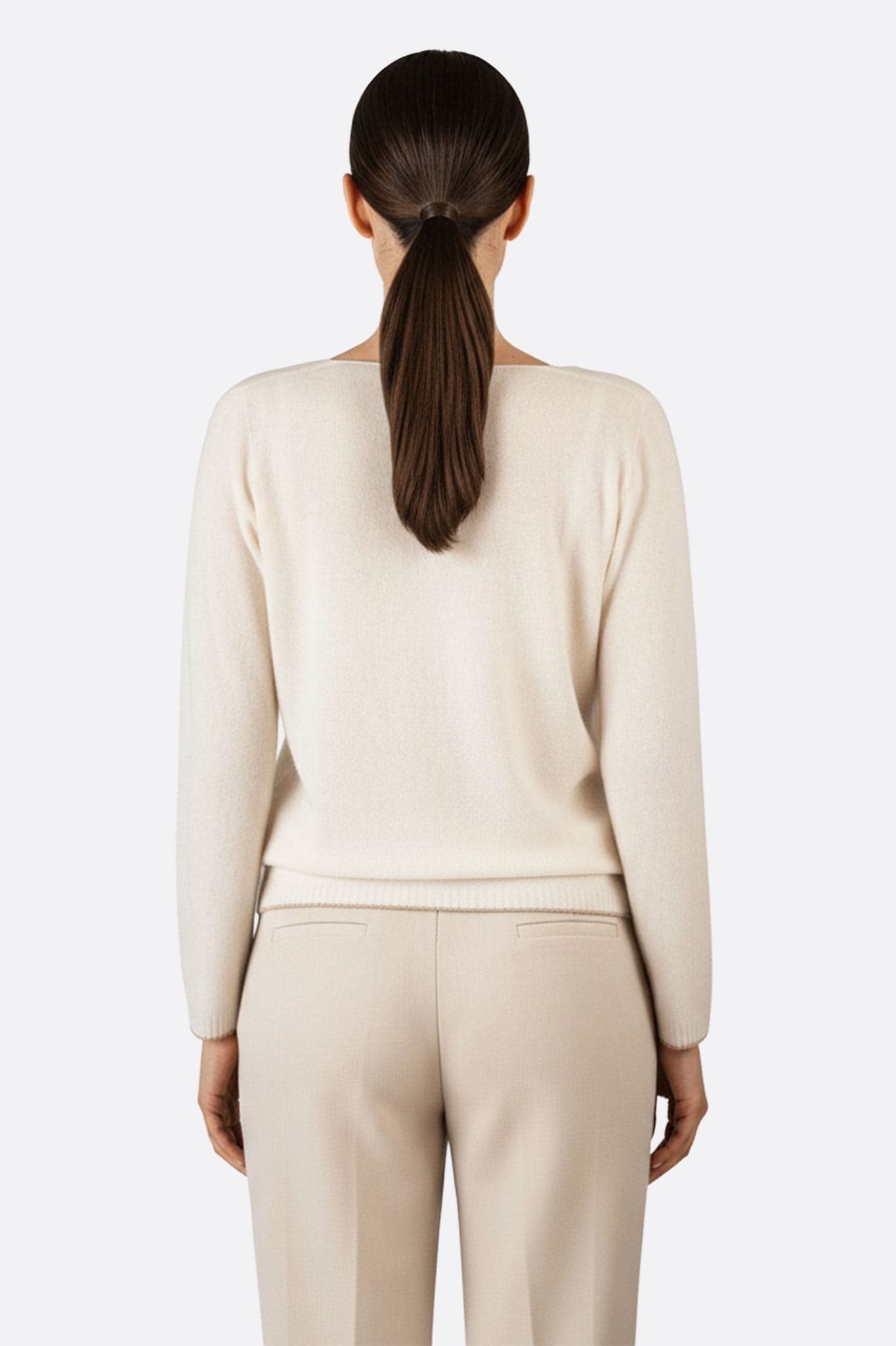 Pull en laine mérinos et cachemire couleur crème, col V et accents dorés, une pièce élégante pour les soirées distinguées.