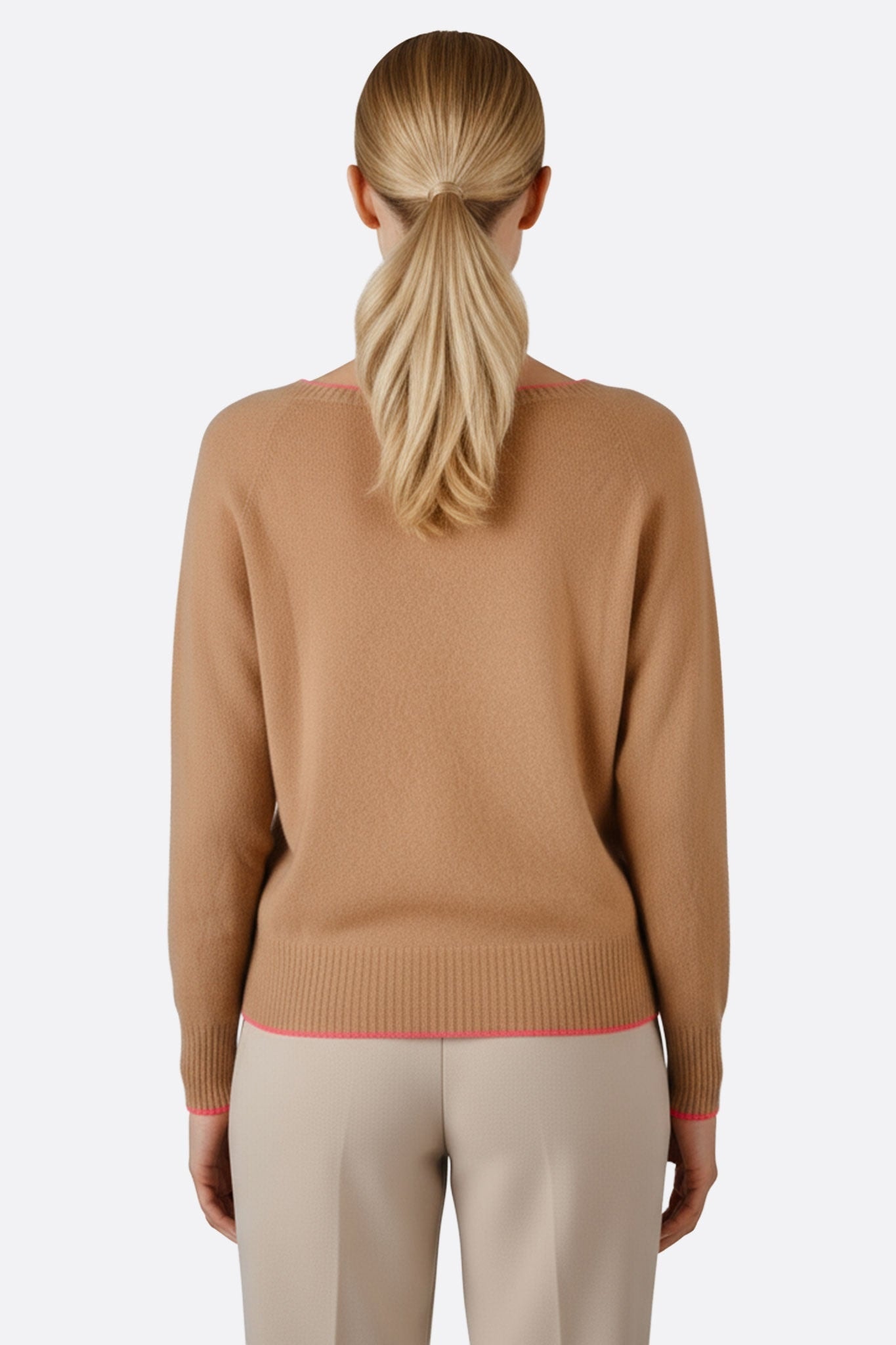 Dettaglio tre quarti di un maglione beige in lana merino, cashmere con bordi rosa fluo, ideale per uno stile moderno e raffinato.