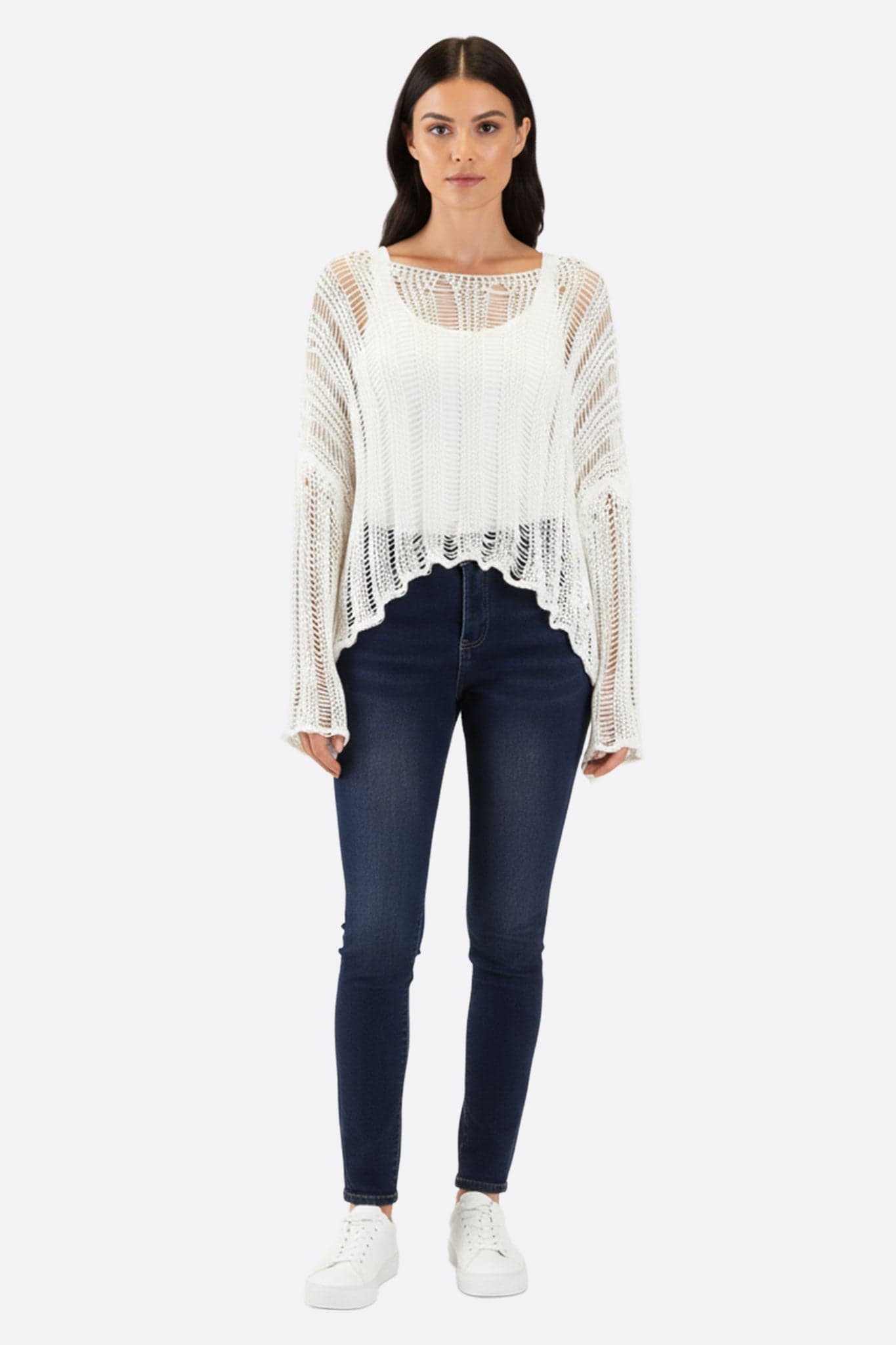 Raffiniertes Detail des weißen Pullovers in Lochmuster, ein modernes Essential für einen anspruchsvollen und luftigen Sommerlook.