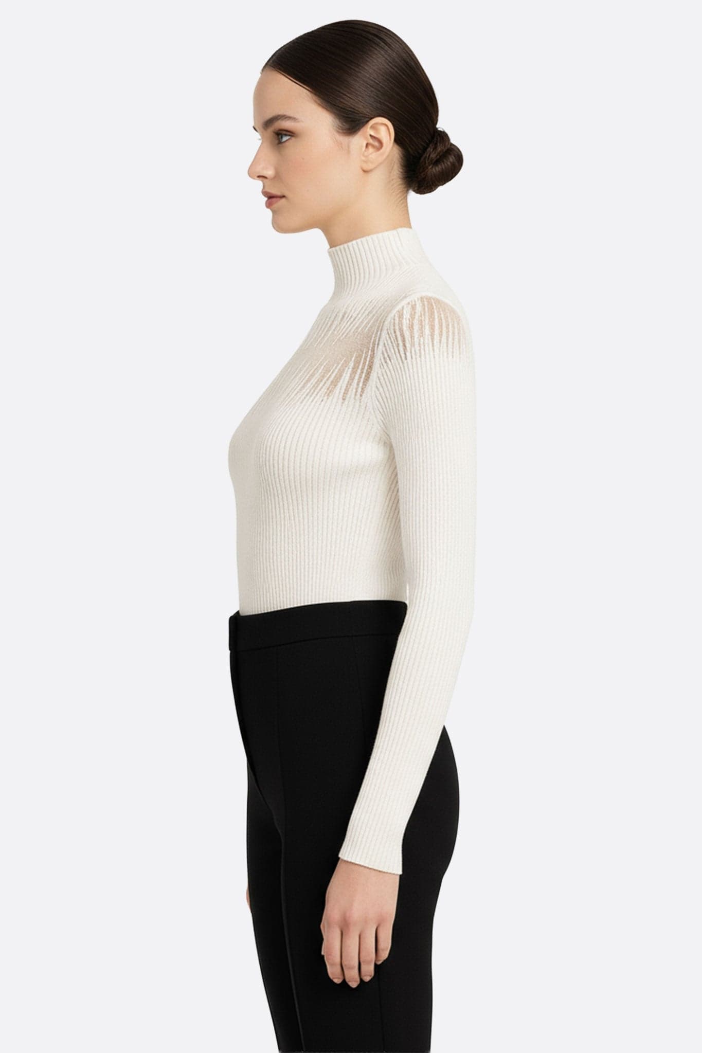 Detail des feinen weißen Langarm-Pullovers, das den transparenten nackten Einsatz für eine raffinierte Ausstrahlung betont.