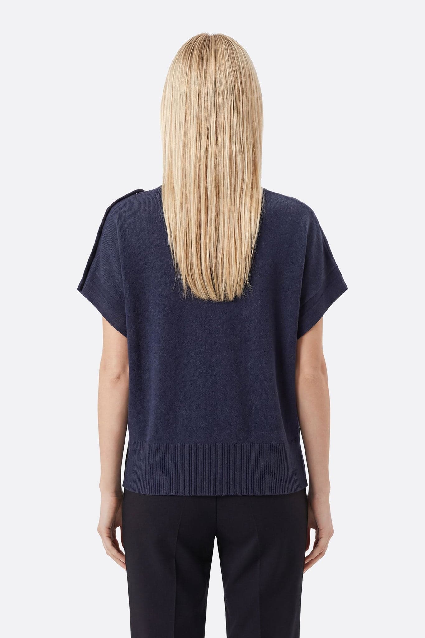 Details on the navy blue sweater with stand-up collar, with buttons and snaps, perfect for a refined evening look.