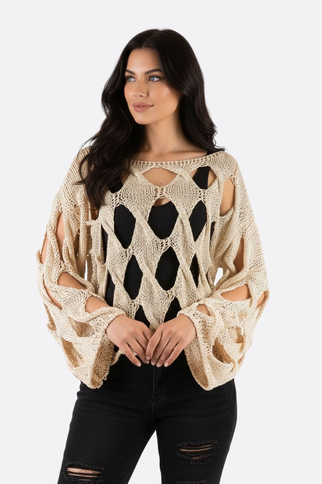 Zoom sur le pull large en maille ajourée, teinte claire, idéal pour une tenue élégante et décontractée en bord de mer.