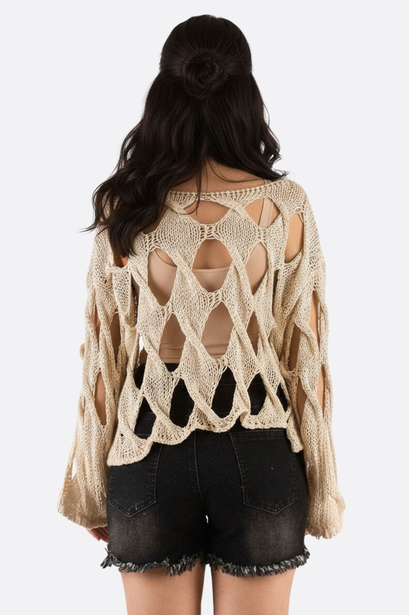 Détail du pull large en maille aérée, couleur crème, parfait pour une allure stylée lors d'une escapade estivale.
