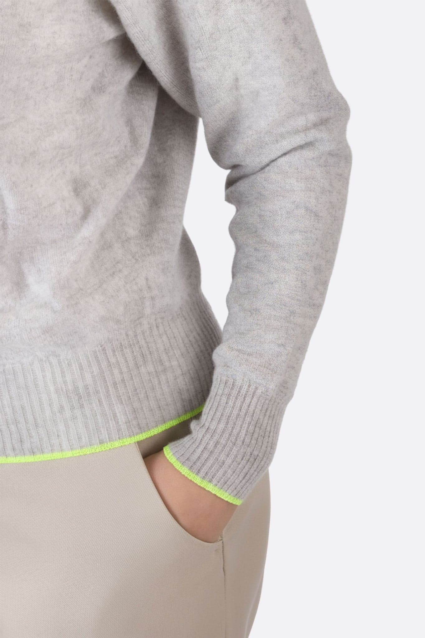Zoom sur le dos d'un pull gris en laine mérinos et cachemire avec accents fluo, alliant confort et style moderne.