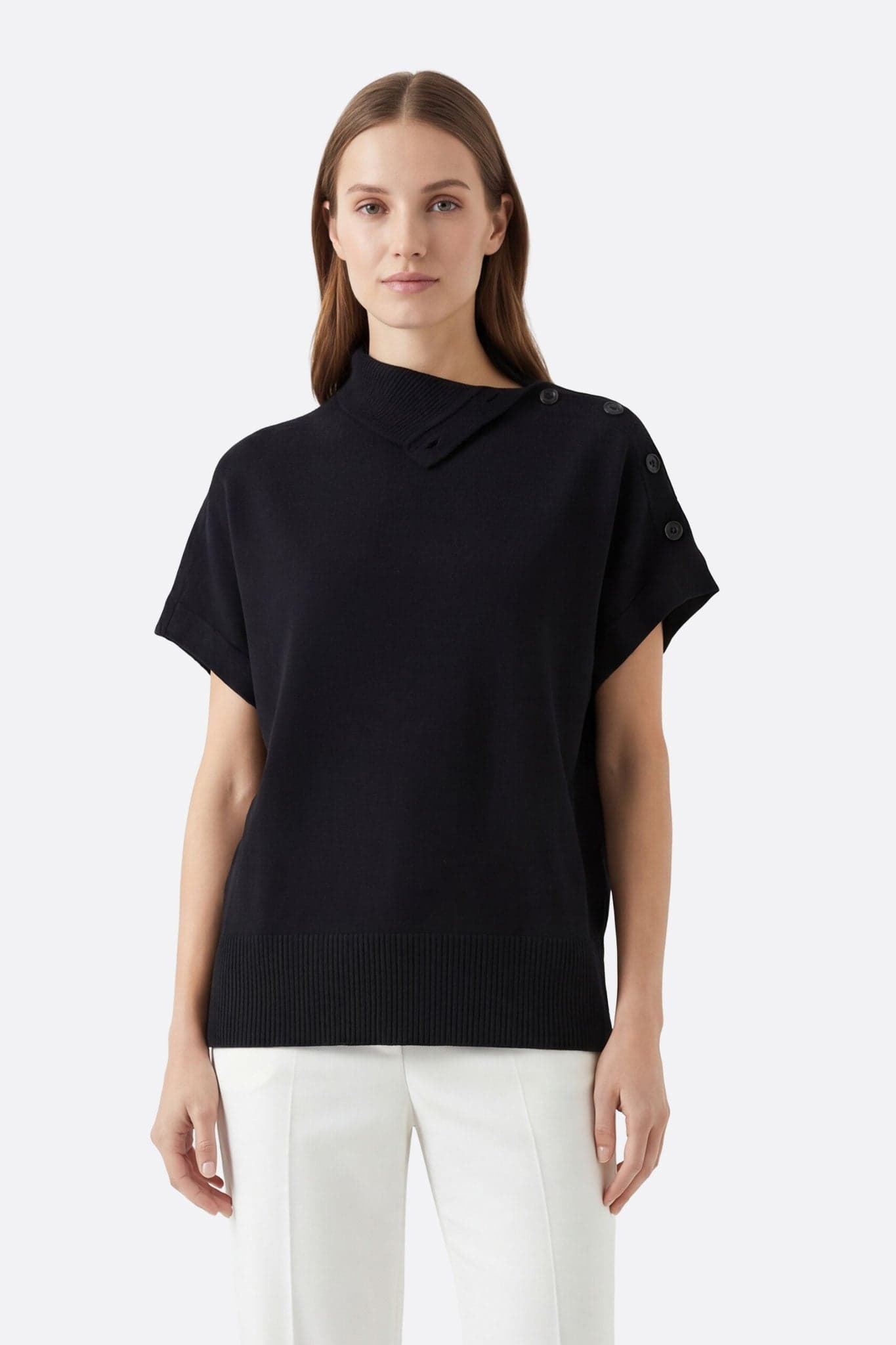 Maglione nero a collo alto abbottonato visto di fronte, evidenziando il taglio oversize e la maglia morbida per un look chic.
