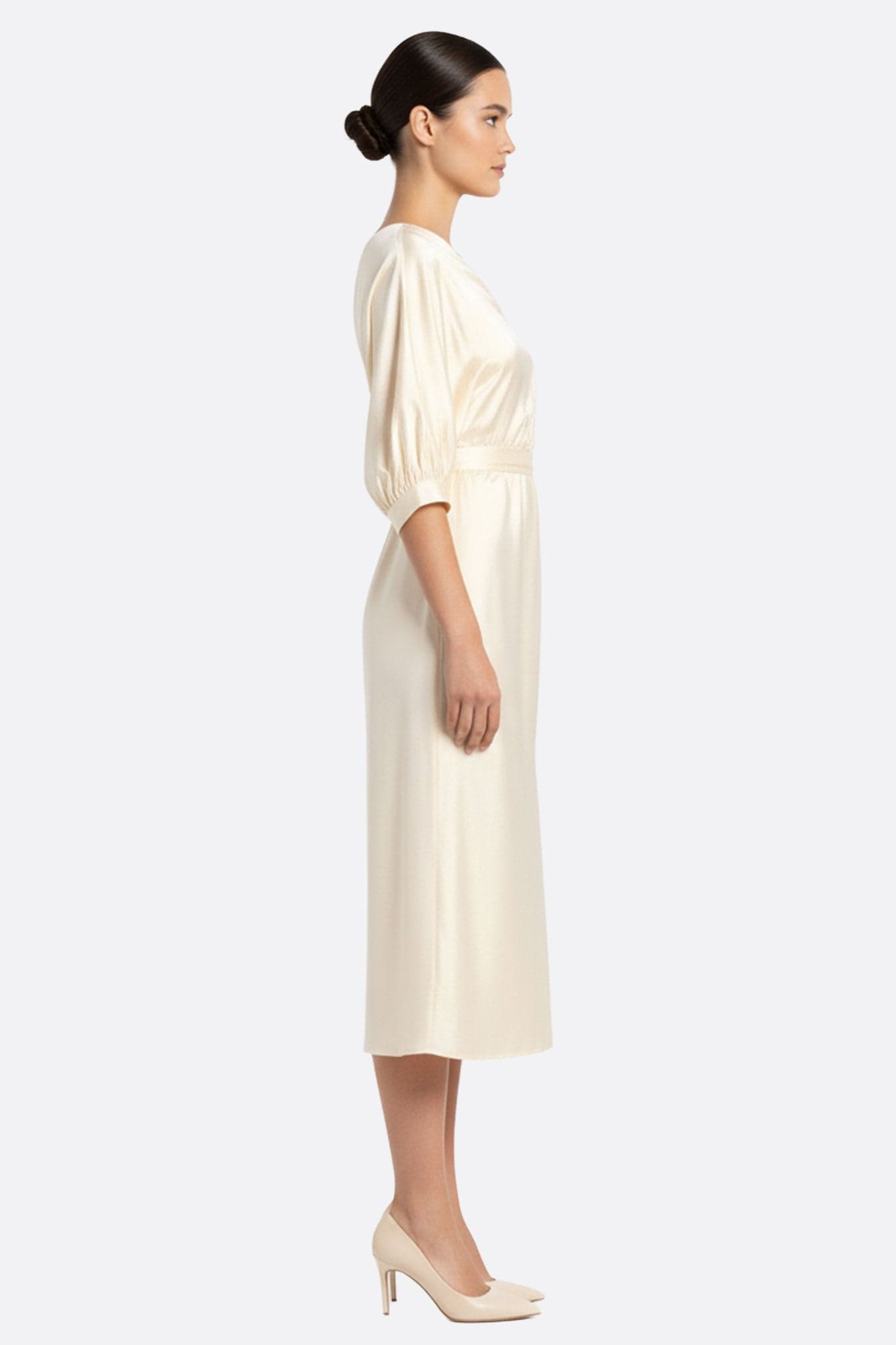 Elegantes Detail des asymmetrischen Kleides in ecru weißem Satin, das den seidigen und modernen Fall für Anlässe hervorhebt...