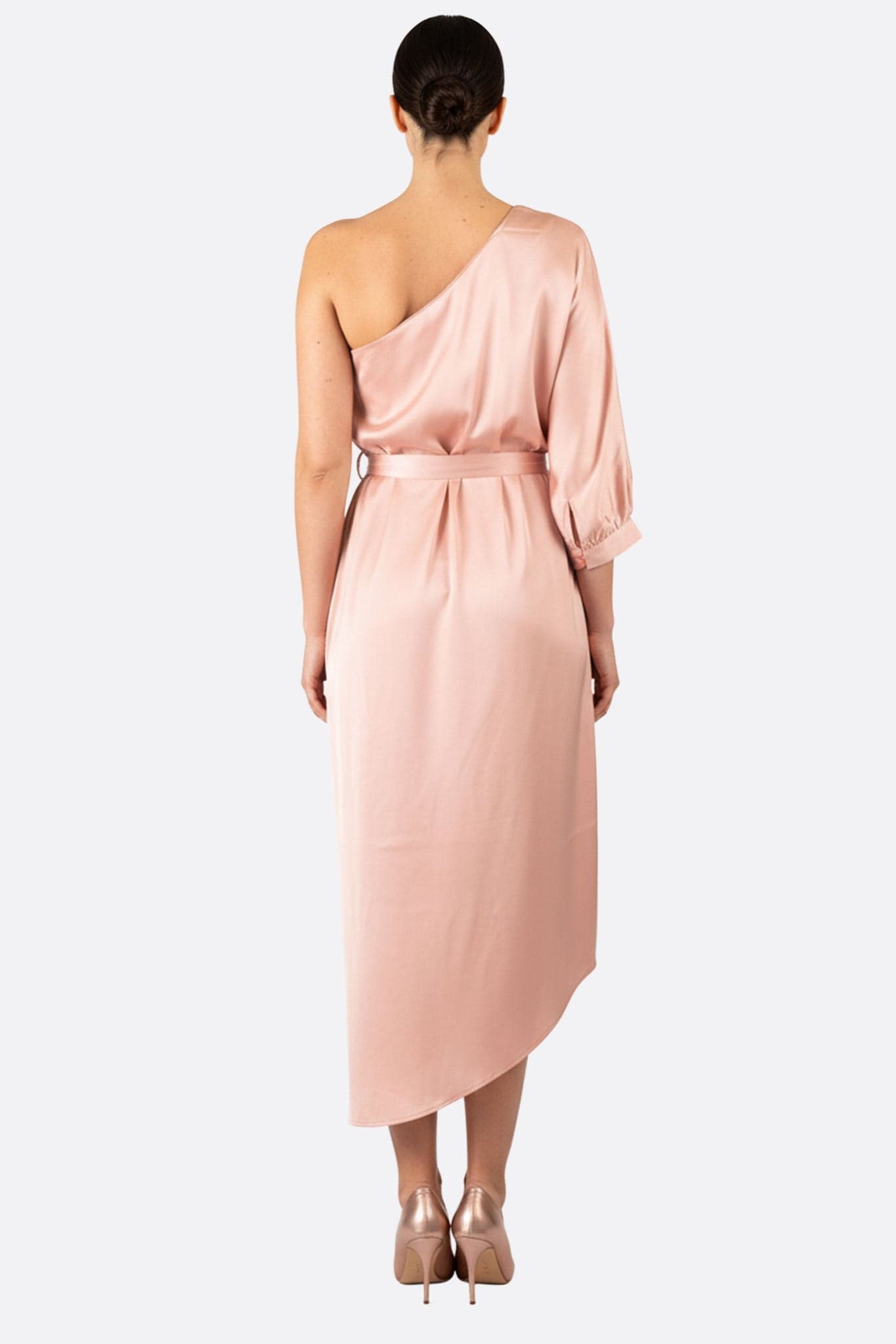 Vue alternative d'une robe asymétrique en satin rose poudré, révélant un drapé fluide et chic pour une sortie élégante.