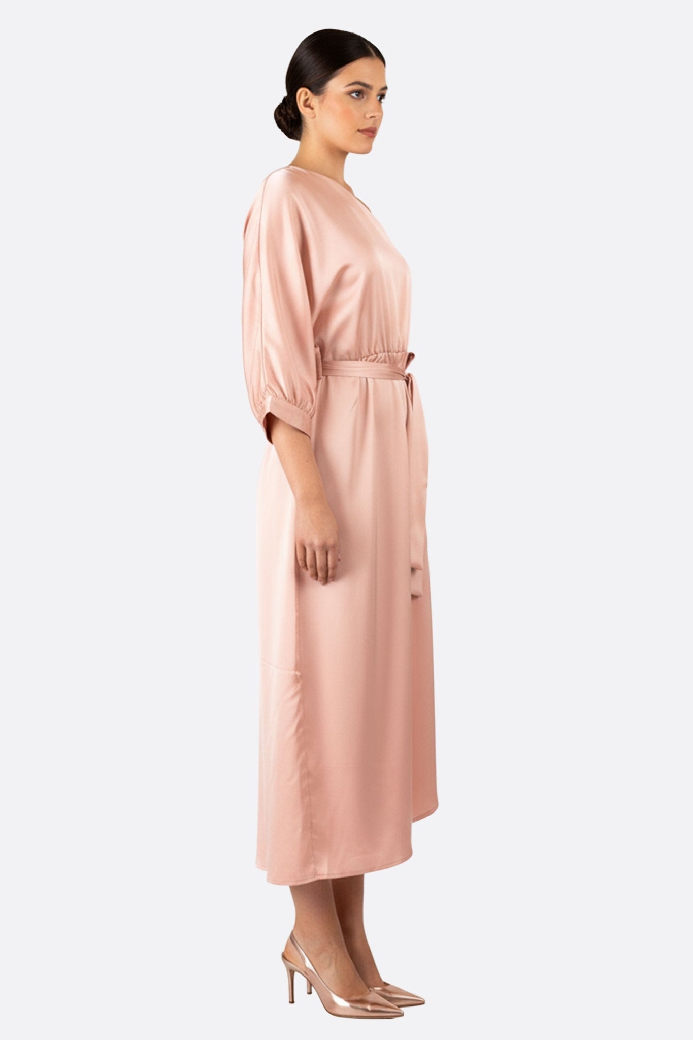 Abito in satin rosa cipria dal design asimmetrico, che mette in risalto un elegante drappeggio, perfetto per occasioni speciali.