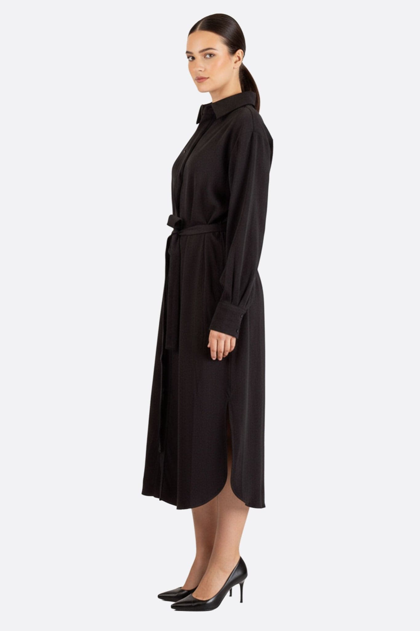 Detail des schwarzen fließenden Hemdkleides mit Knöpfen, minimalistischer Stil für einen modernen und anspruchsvollen Look.