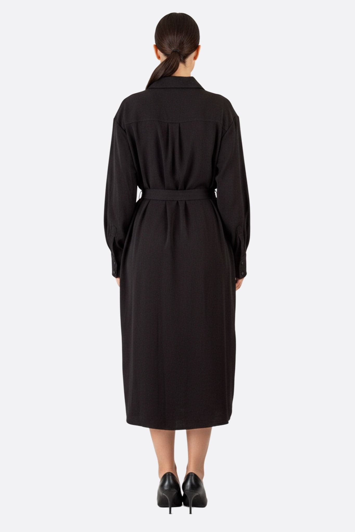 Nahaufnahme der zarten Textur des schwarzen Hemdkleides mit Knöpfen, perfekt für einen raffinierten und eleganten Alltagsstil.
