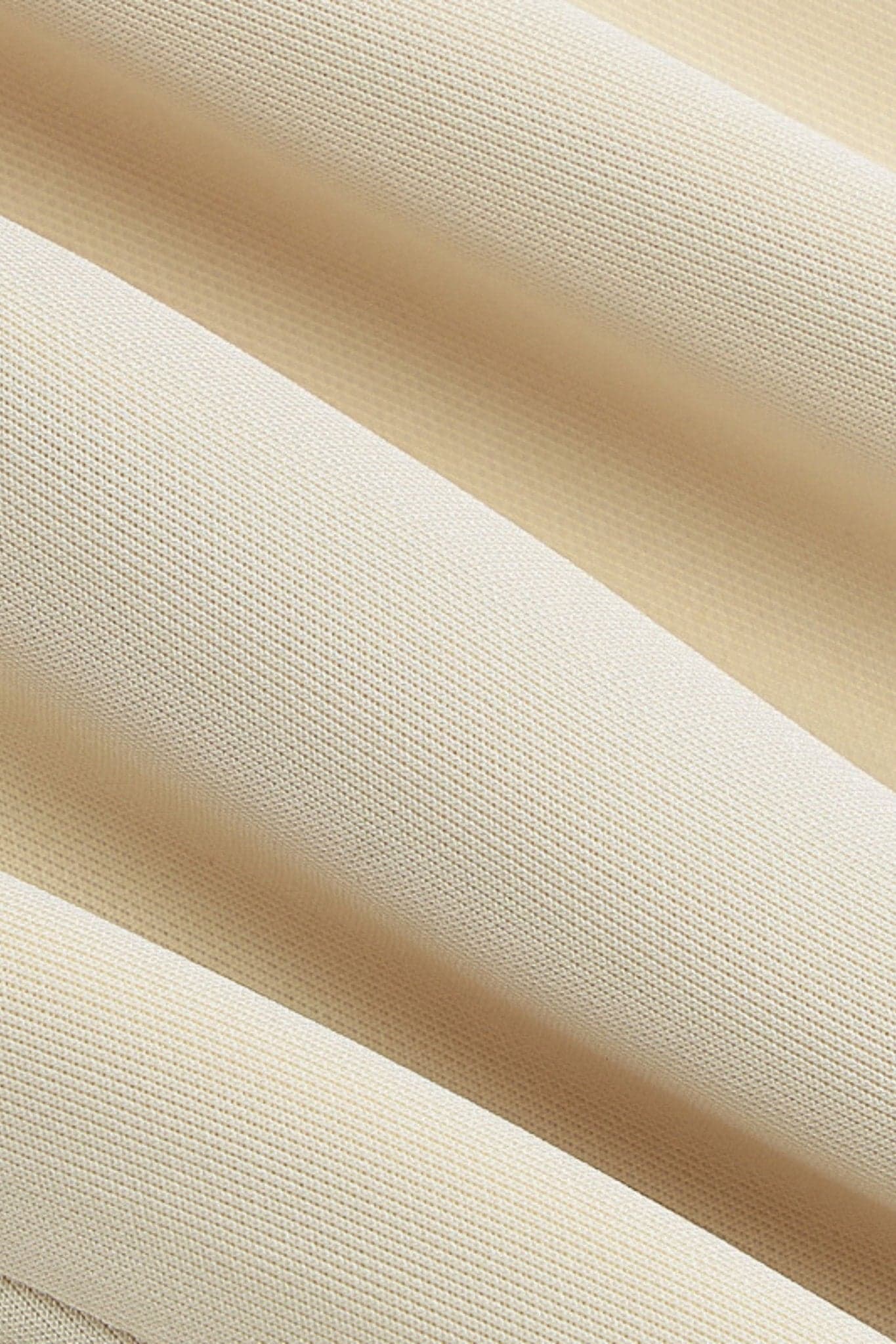 Perspectiva alternativa del vestido corto evasé beige, revelando su escote seductor y su encanto atemporal.