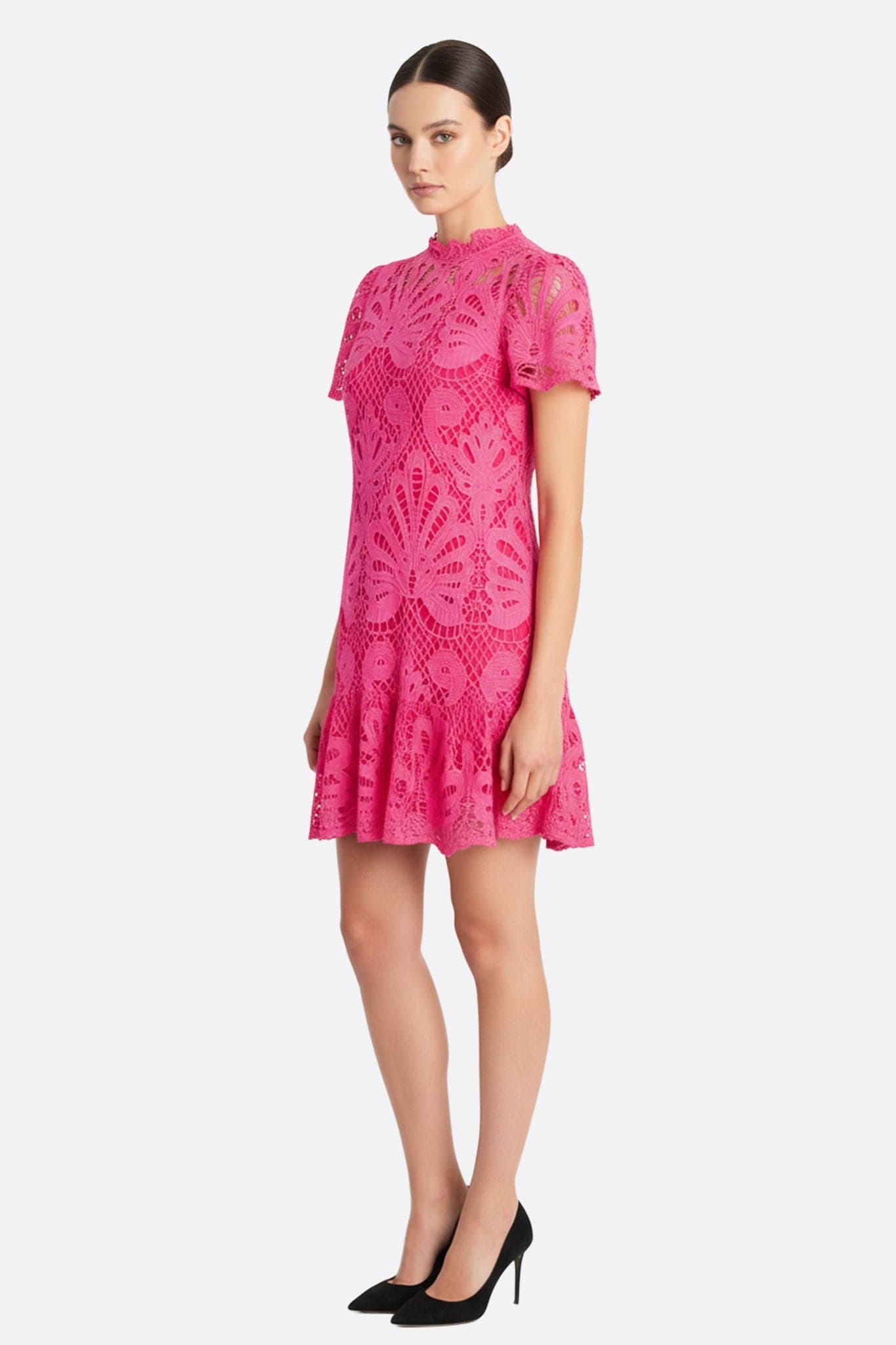 Alternative Perspektive des kurzen fuchsiaroten Spitzenkleides, die das Lochmuster und die kühne Eleganz hervorhebt.