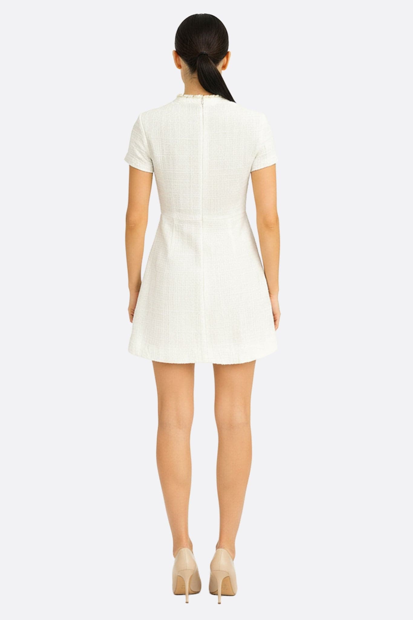Détail élégant de la robe courte en tweed ivoire à col perlé doré, révélant sa sophistication pour une occasion spéciale.