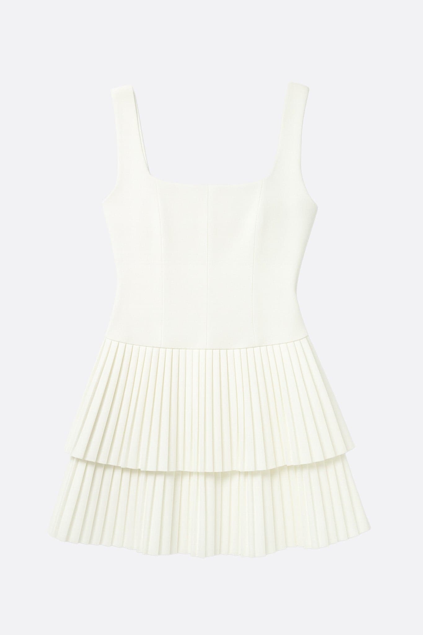 Détail de la robe courte évasée blanche, jupe plissée révélant un style raffiné et frais, parfait pour des événements chics.