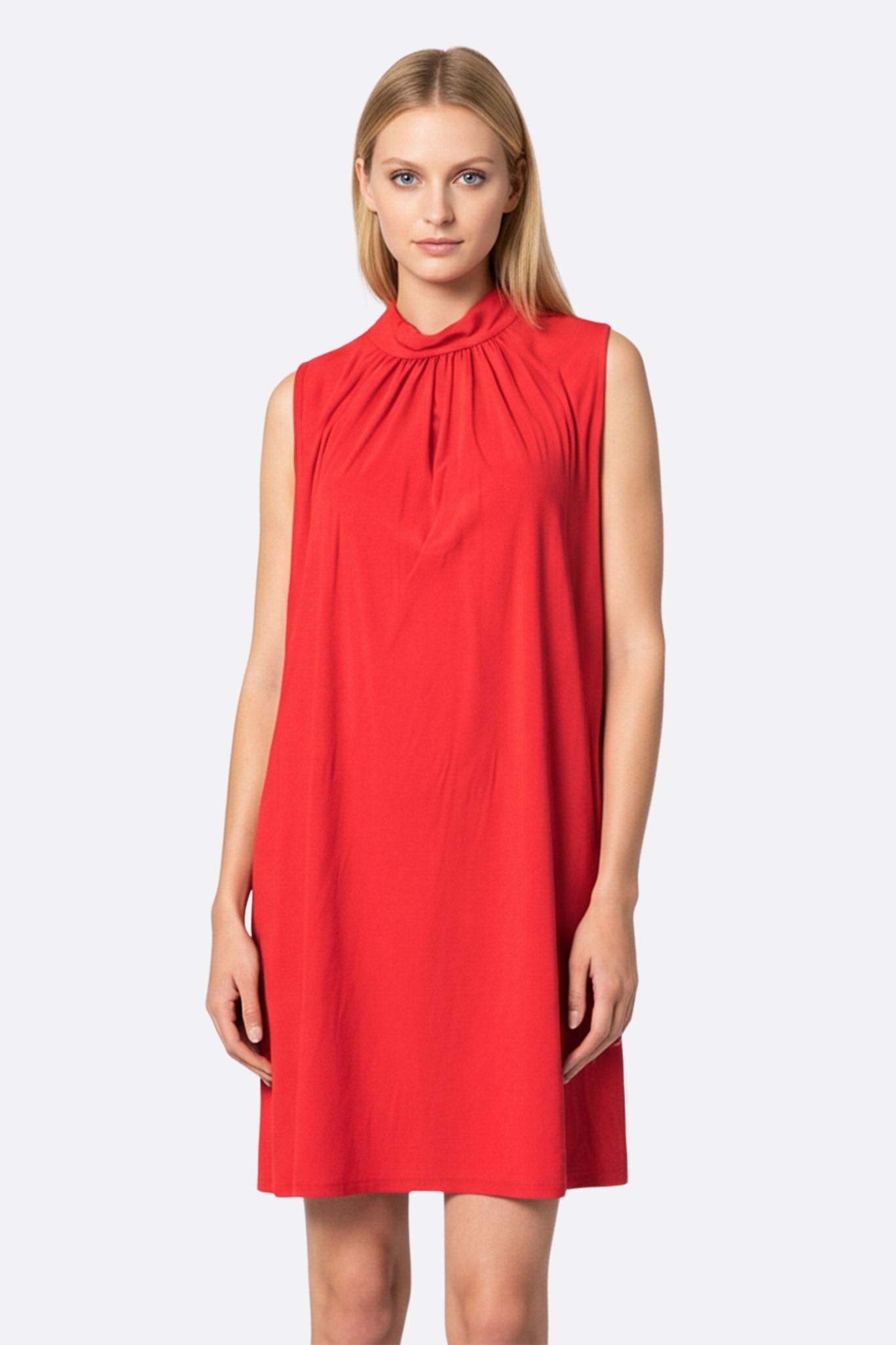 Flowing red dress with draped neckline, perfect for an elegant evening, highlighting its lightness and timeless charm.