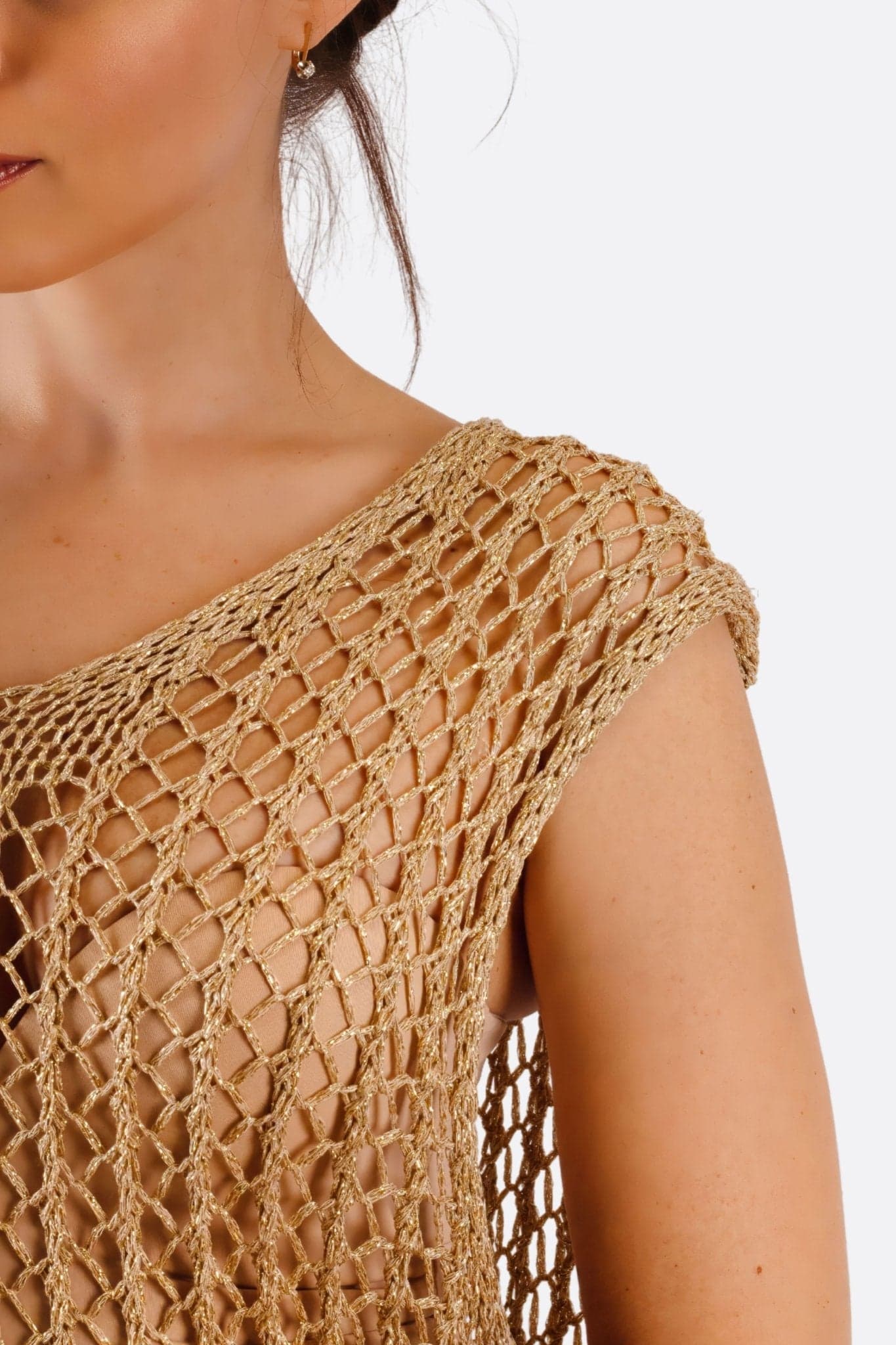 Détail du dos de la robe longue en maille crochet beige, mettant en avant sa texture délicate et son allure sophistiquée.