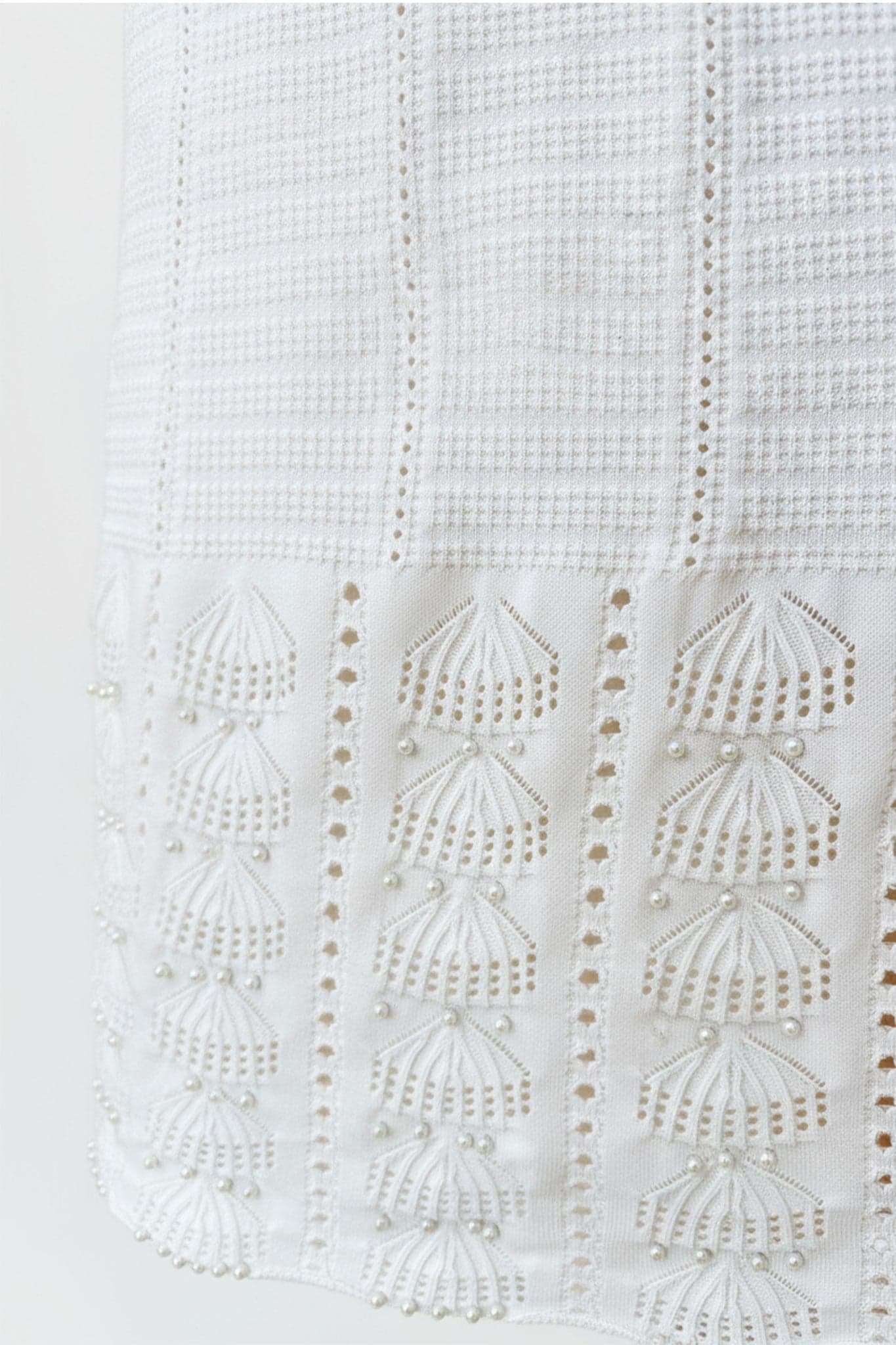 Weißes langes Kleid aus Perlenstrick, alternative Ansicht, die seine Fließfähigkeit und Eleganz offenbart, perfekt für Abende...