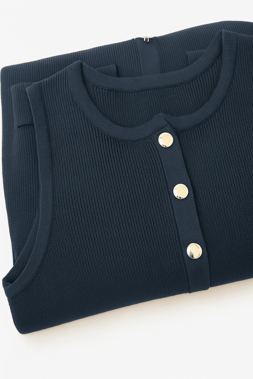 Sleeveless navy blue ribbed knit dress, close-up on the elegant texture and refined buttons, perfect for the...