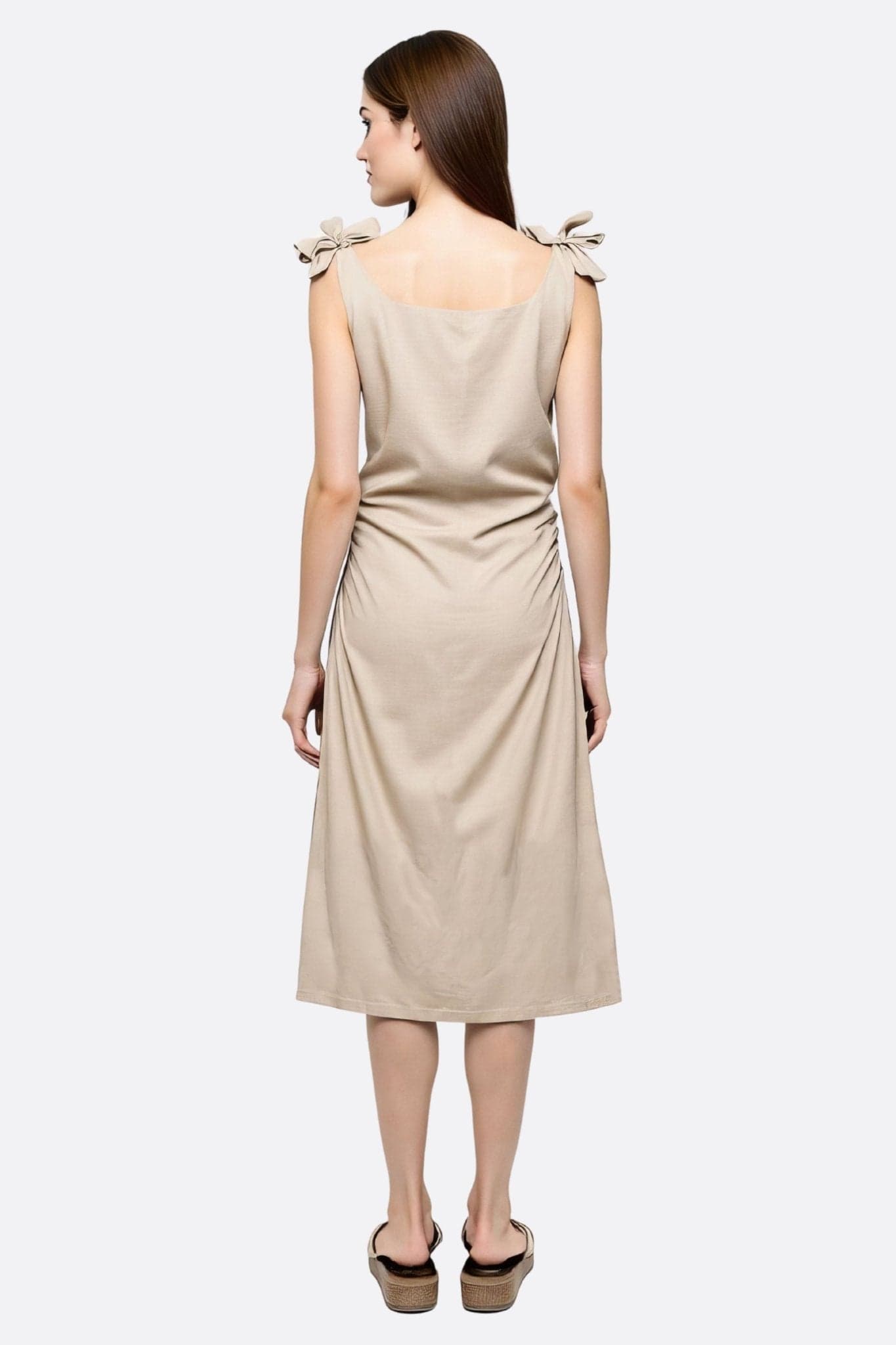 Détails de la robe longue en lin beige sable, mettant en valeur sa texture légère et sa coupe fluide pour un look chic au...