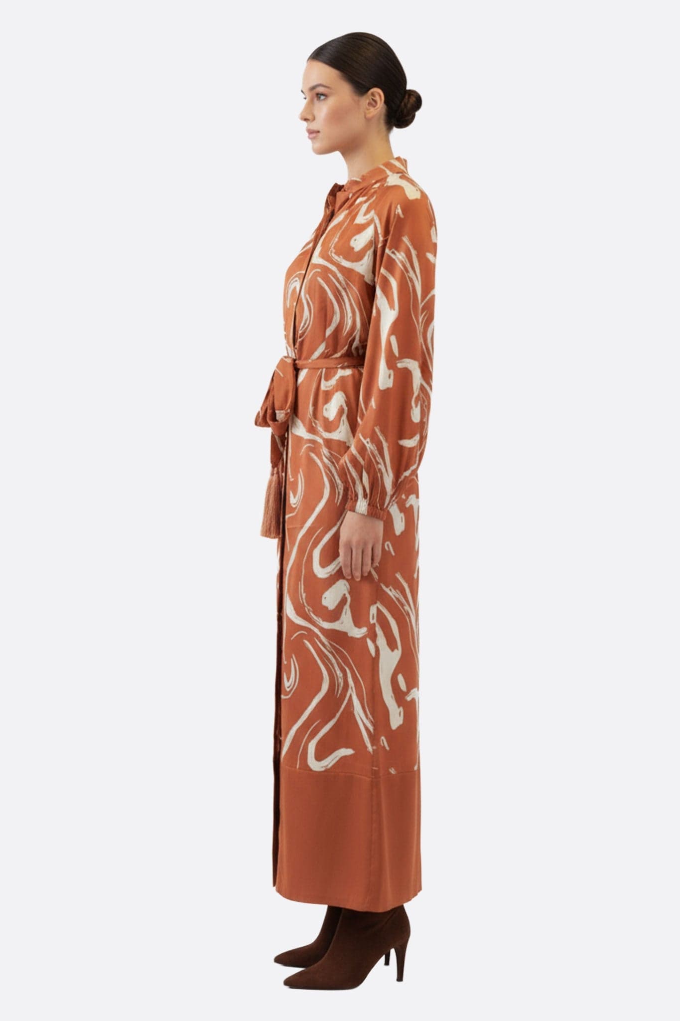 Seitliches Detail eines braunen langen Kleides mit Marmordruck, vom Kimono inspiriert, perfekt für raffinierte Anlässe.