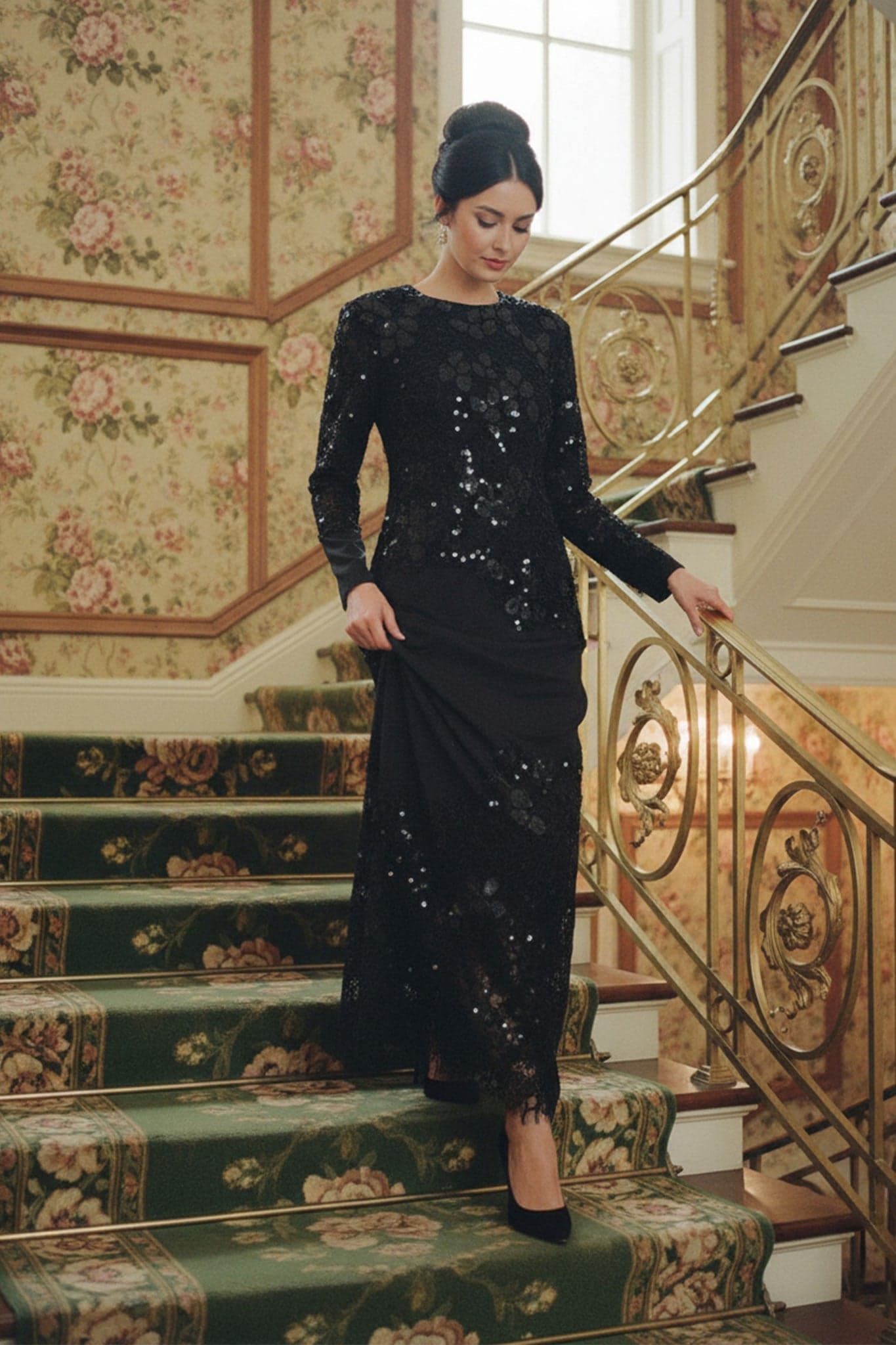 Dettaglio elegante dell'abito lungo nero in pizzo e paillettes, che rivela la leggerezza delle maniche lunghe per una serata...