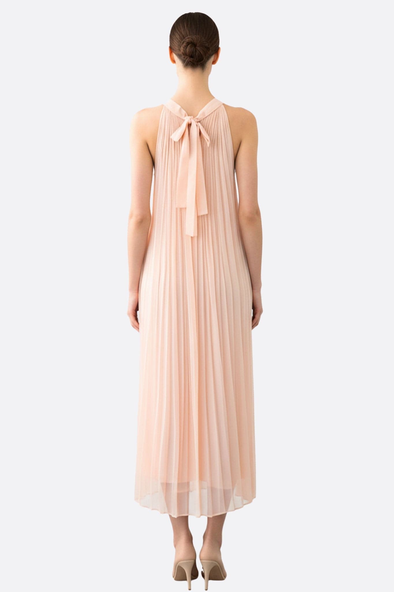 Details des langen Kleides aus blassrosa Chiffon, die seine harmonischen Falten und seinen zeitlosen Charme für einen... hervorheben.