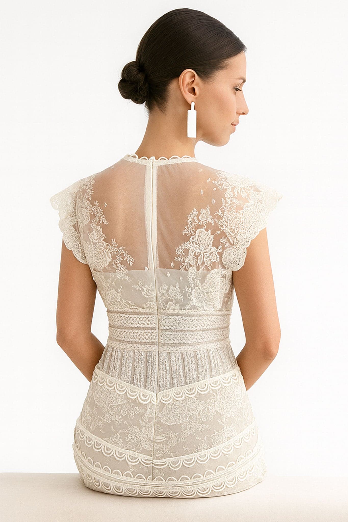 Hervorhebung der zarten Stickereien des Midi-Kleides in weißer Spitze, perfekt für ein raffiniertes Boho-Outfit