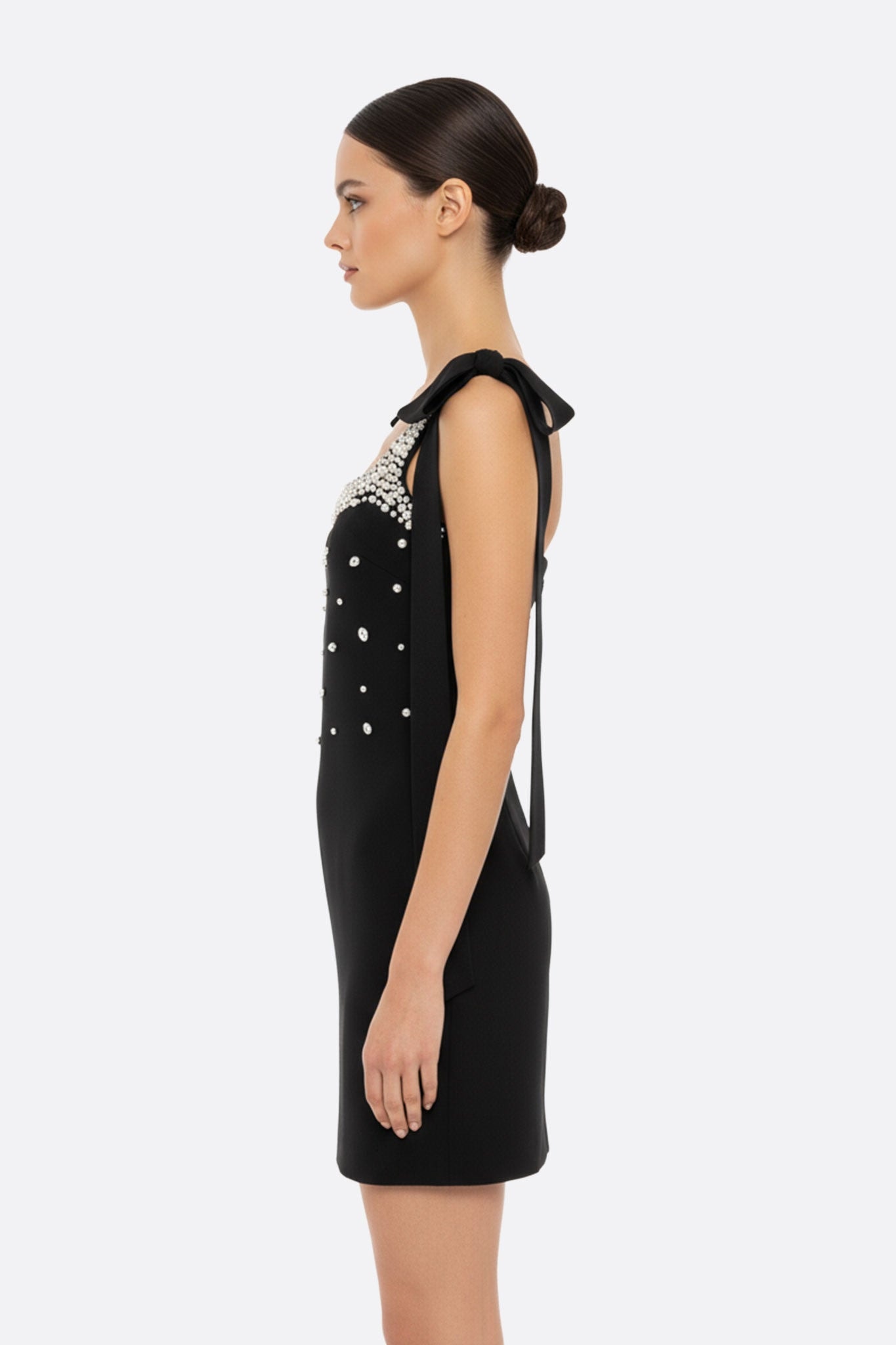 Élégante robe noire courte ornée de perles scintillantes et de nœuds raffinés, parfaite pour des événements chics.