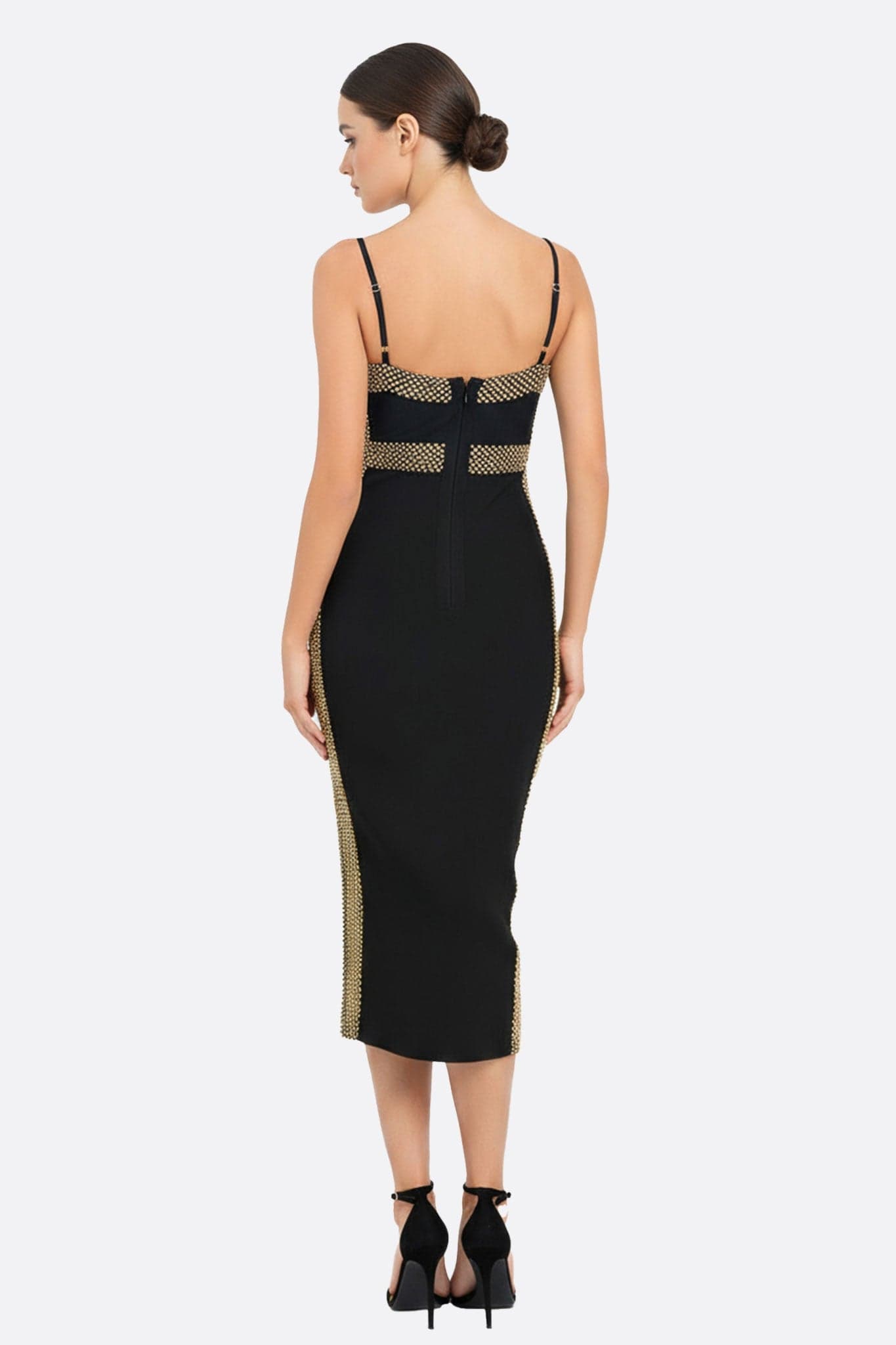 Captivating detail of the black midi dress in sculpting knit, highlighting the delicate golden shimmer, for a chic look.