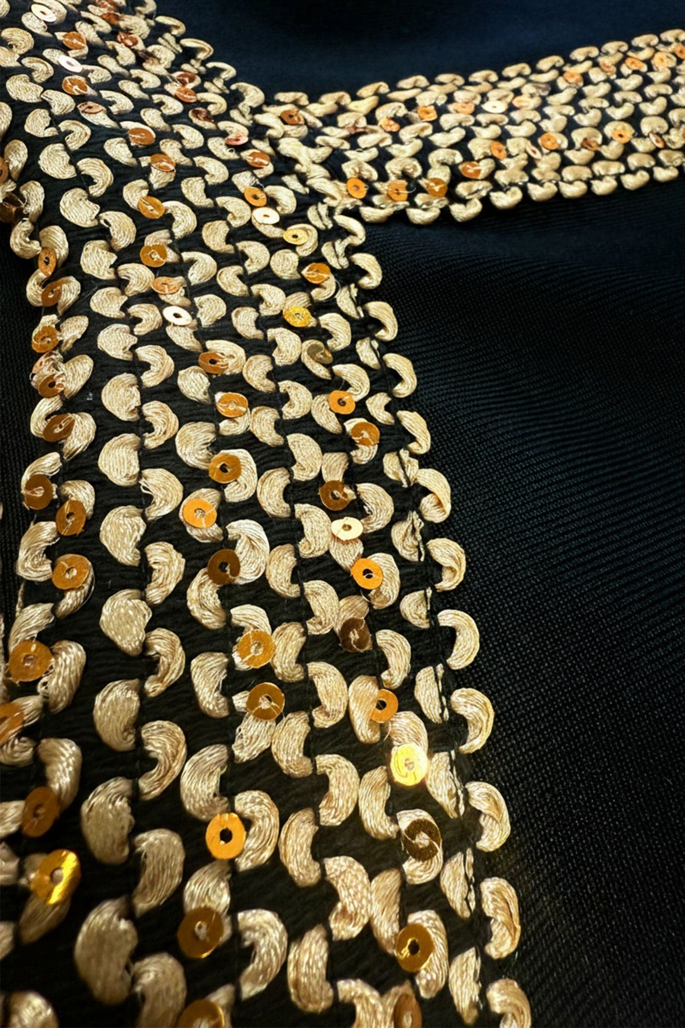 Detail of the back of the black midi dress in sculpting knit adorned with golden shimmer, perfect for chic and glamorous evenings.