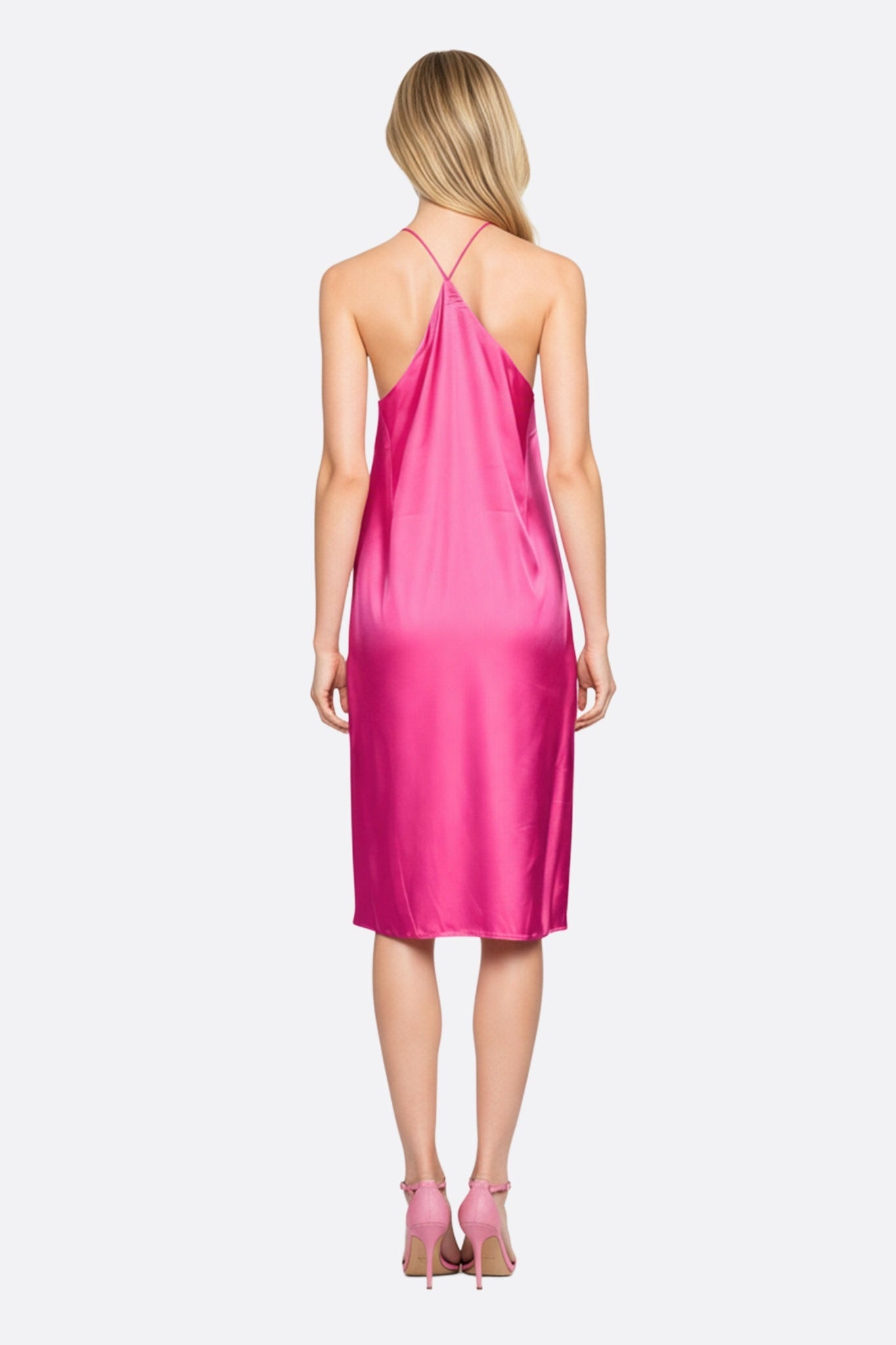 Robe fluide en satin fuchsia, accentuée par des chaînettes de strass argentés, parfaite pour une soirée estivale chic.
