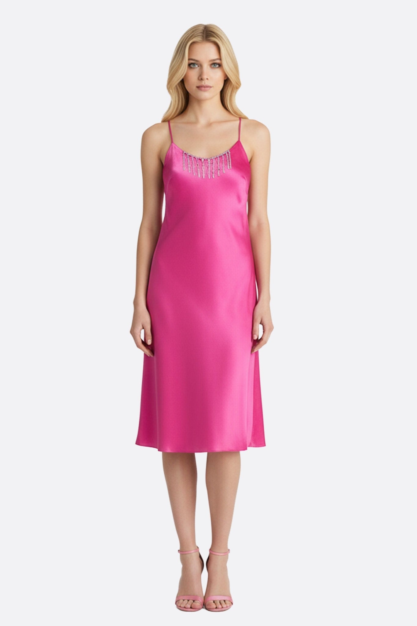 Robe fuchsia en satin, mettant en valeur ses chaînettes de strass argentés pour une allure élégante et lumineuse.