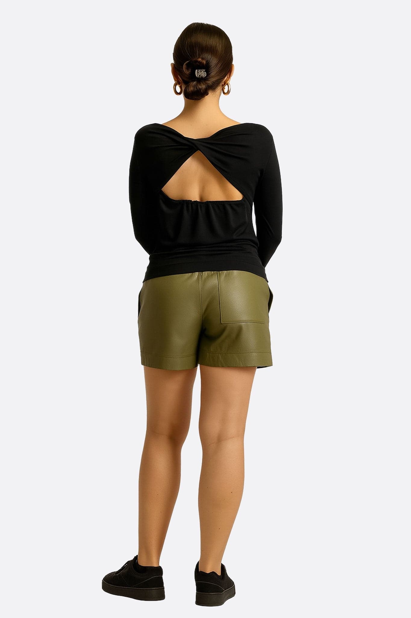 Rückdetail der Khaki-Kunstleder-Shorts, das den raffinierten Schnitt und die Flexibilität des eleganten elastischen Bundes zeigt.